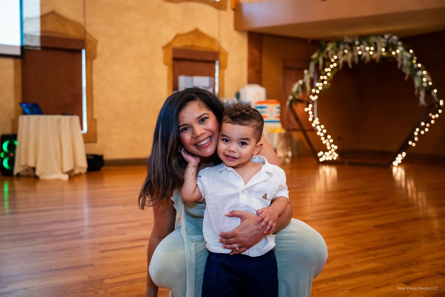 Special moment captured at an indoor event with decorative arch in background.
