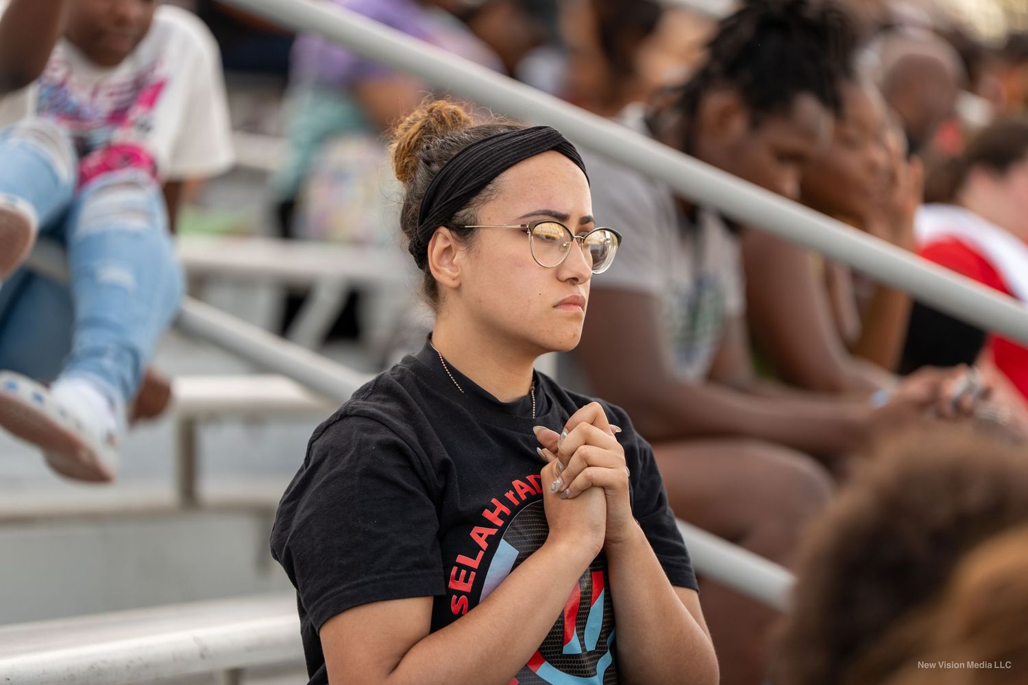 People watching attentively in stadium seats during an outdoor event.