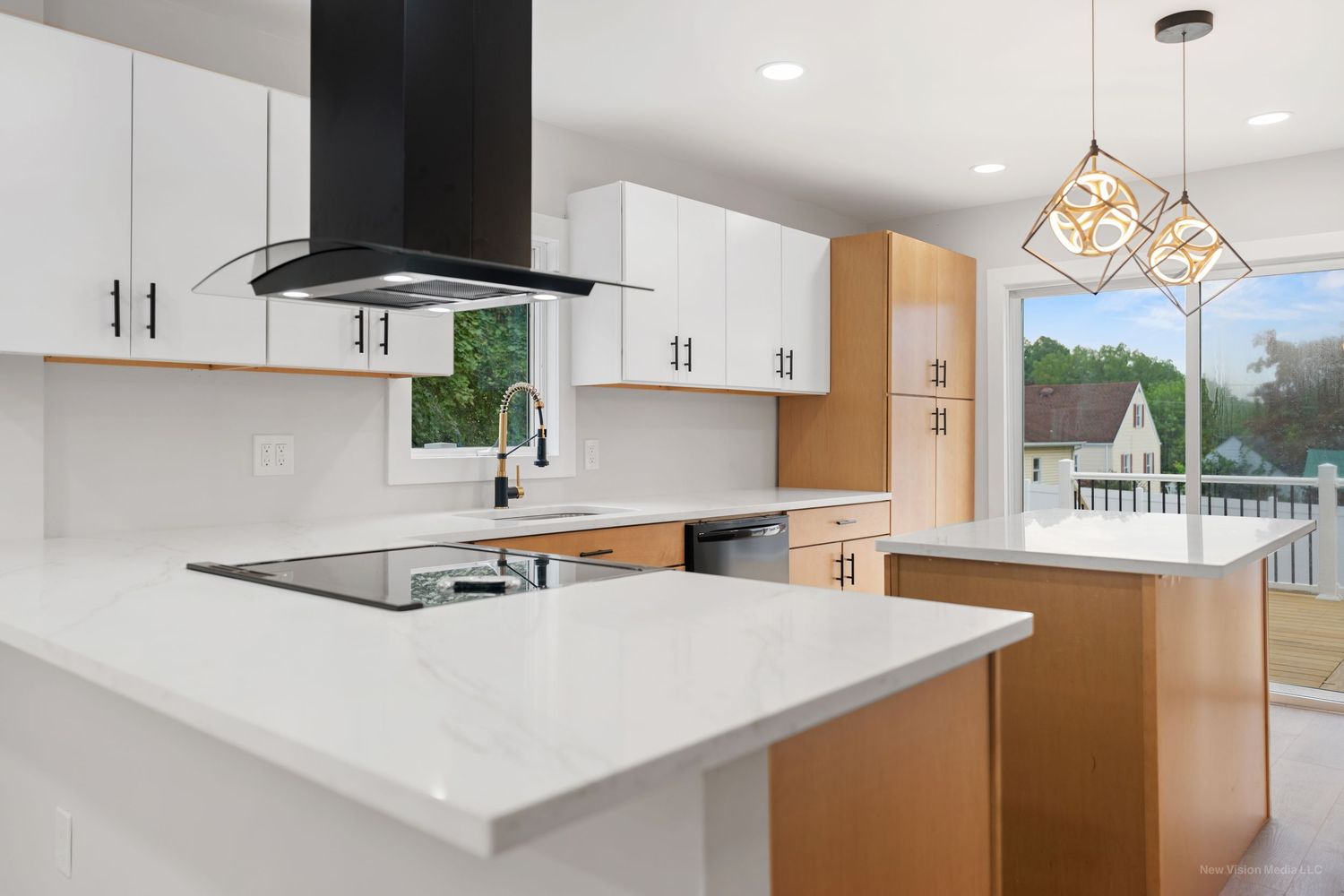 Modern white kitchen renovation showcases pendant lighting, sleek cabinetry and quartz countertops in an open floor plan.