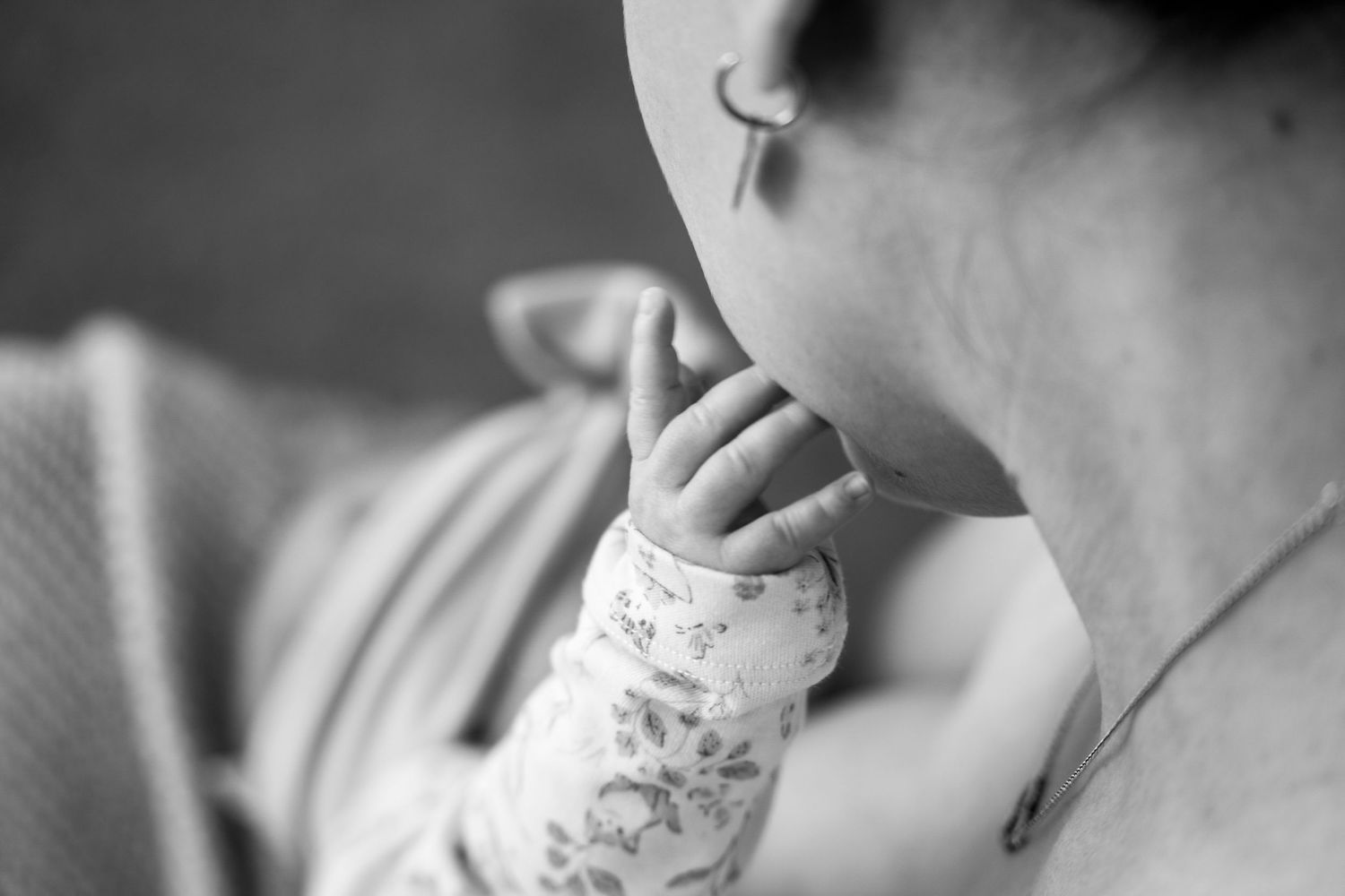 baby stroking mother's face while feeding