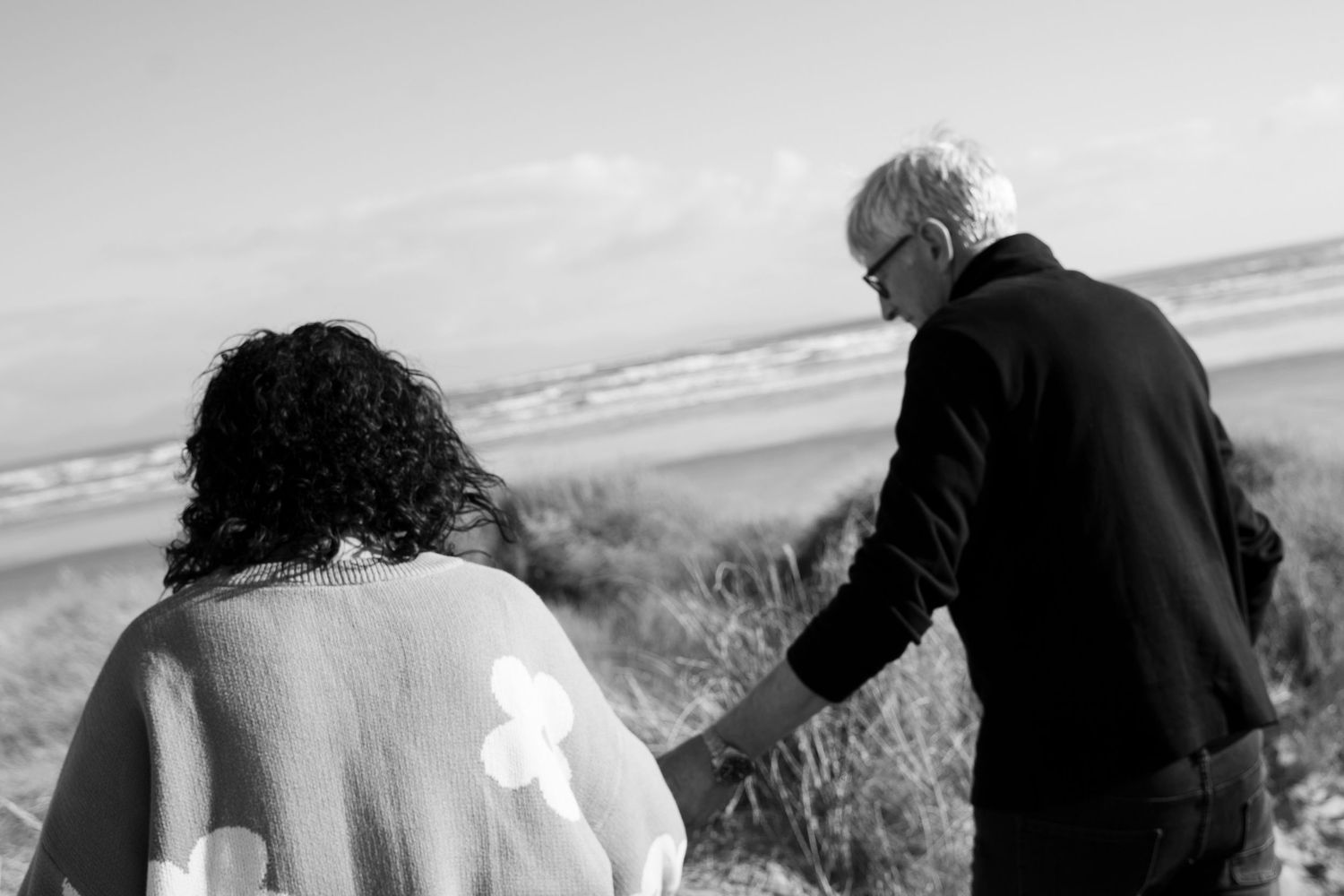 people holding hands at the beach