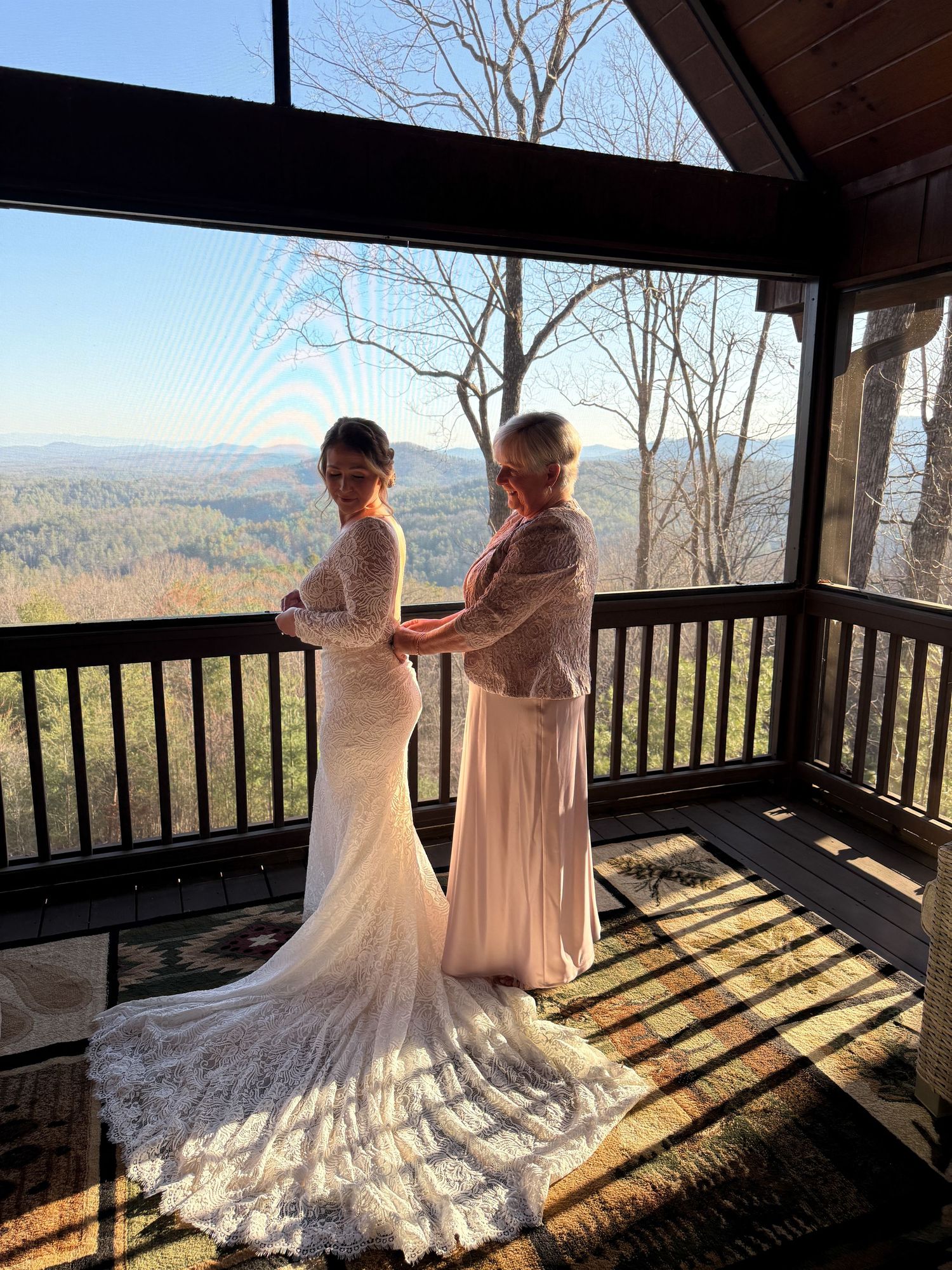 Silhouettes against mountain views in a rustic wedding venue with dramatic lighting.