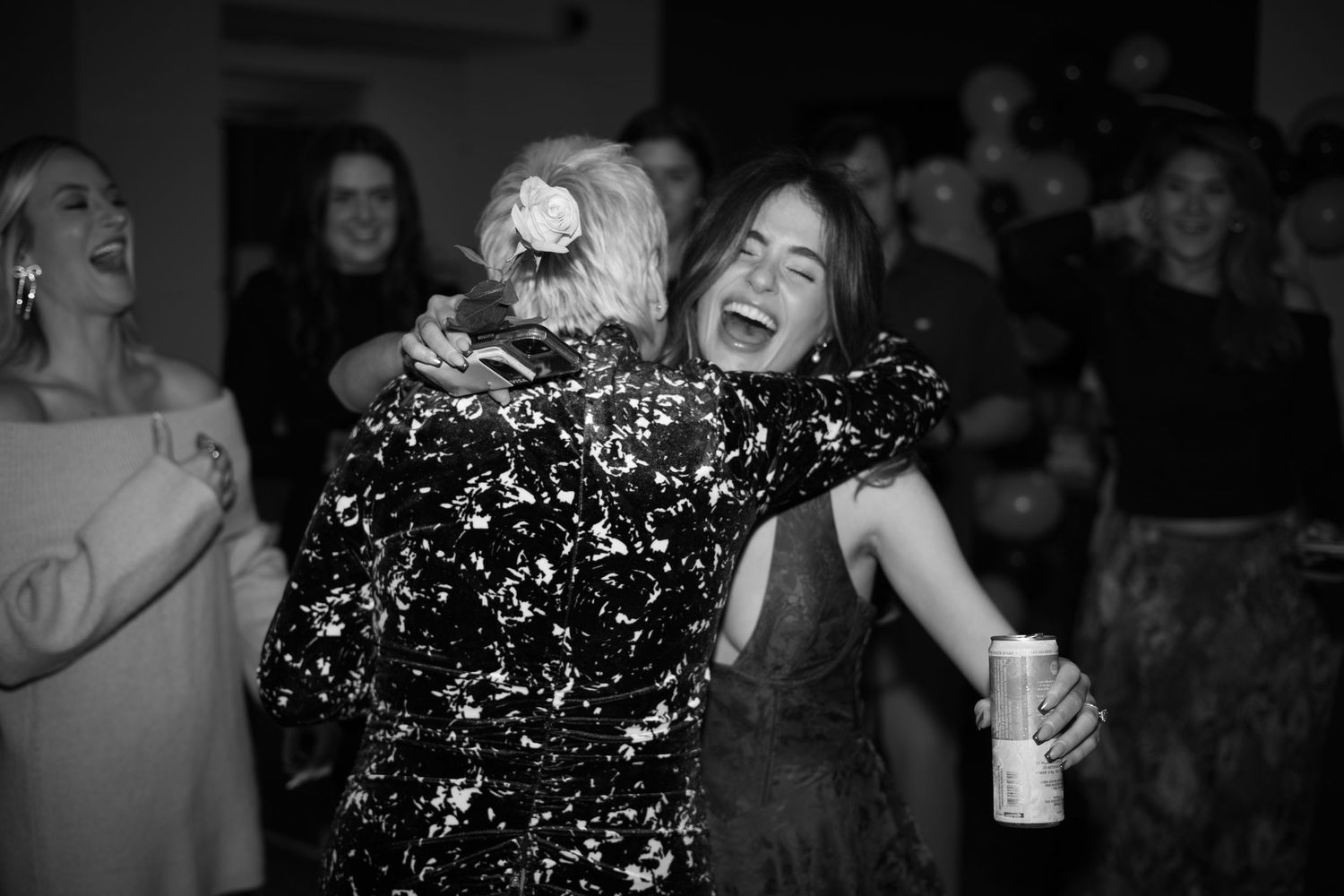 A lively party scene with people dancing and celebrating in black and white.
