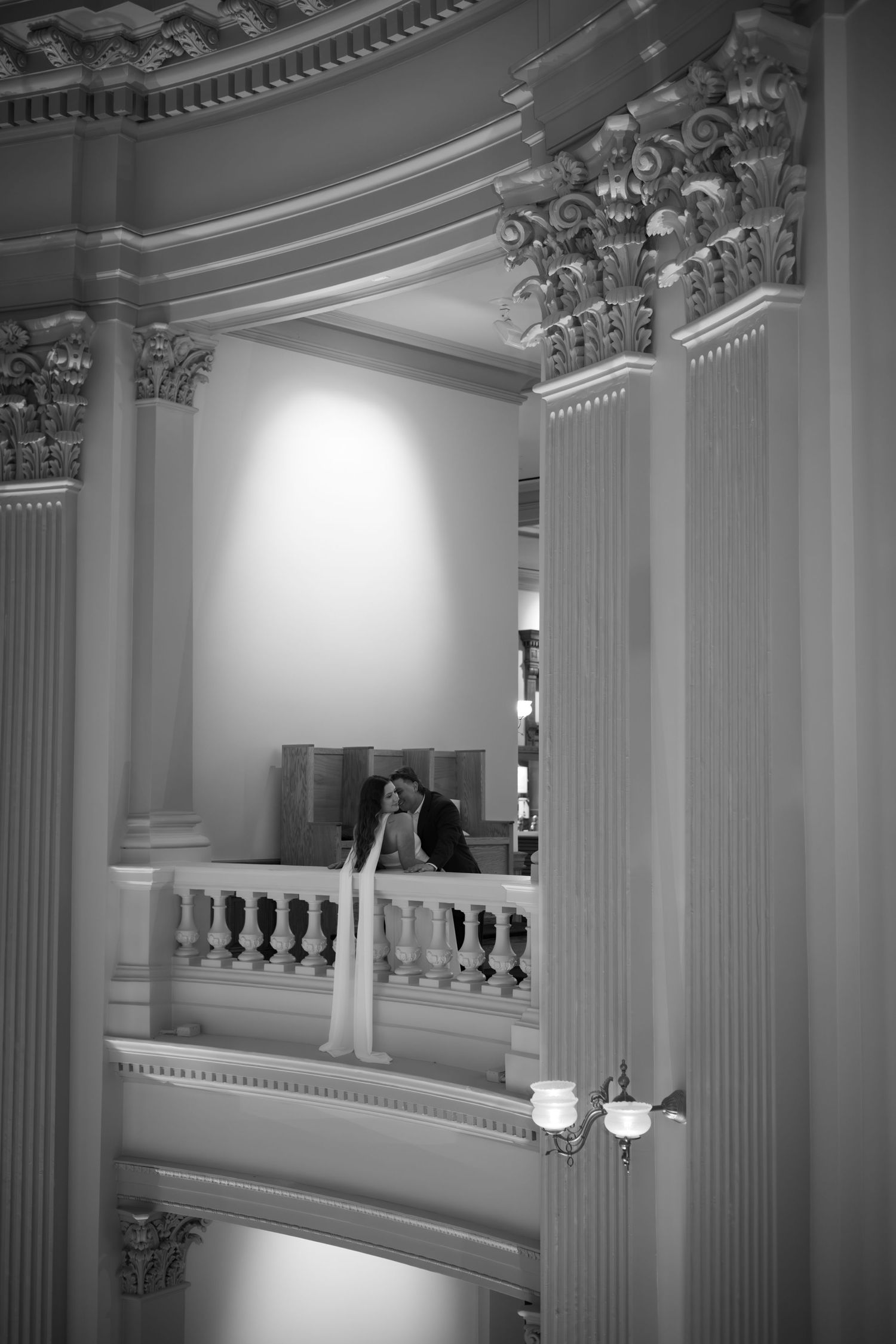 Black and white architectural photos showcase ornate columns and balconies in a grand interior space.