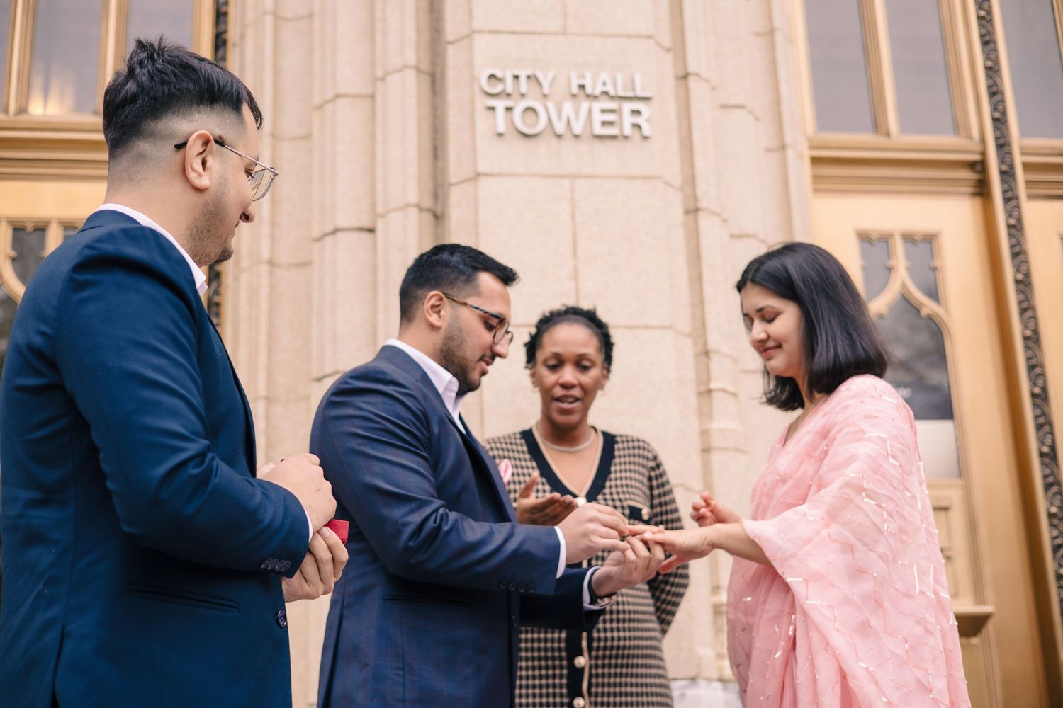 People gathered in formal attire at a city hall or government building entrance.