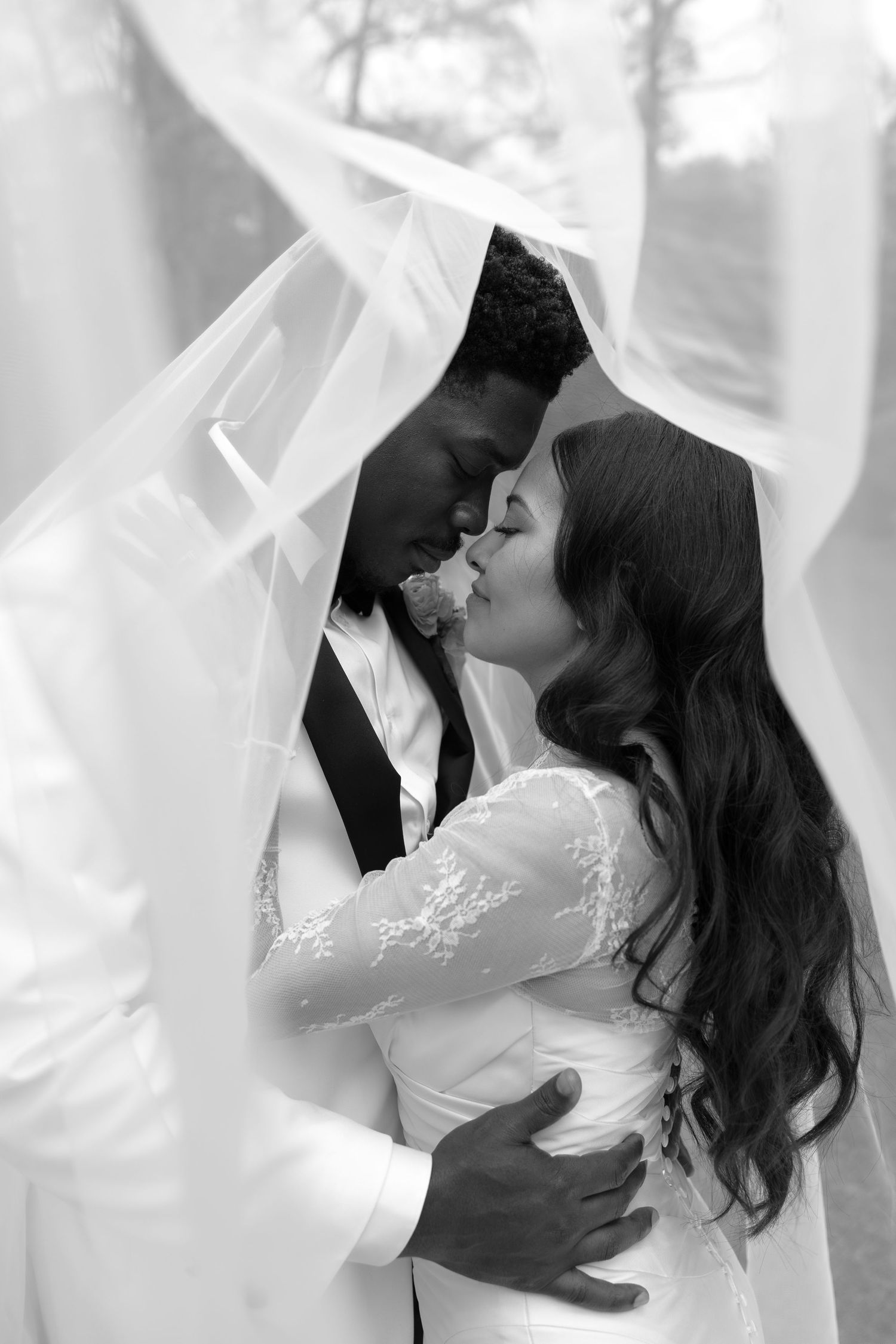 Romantic black and white wedding photos showing tender moments between newlyweds with flowing veil.