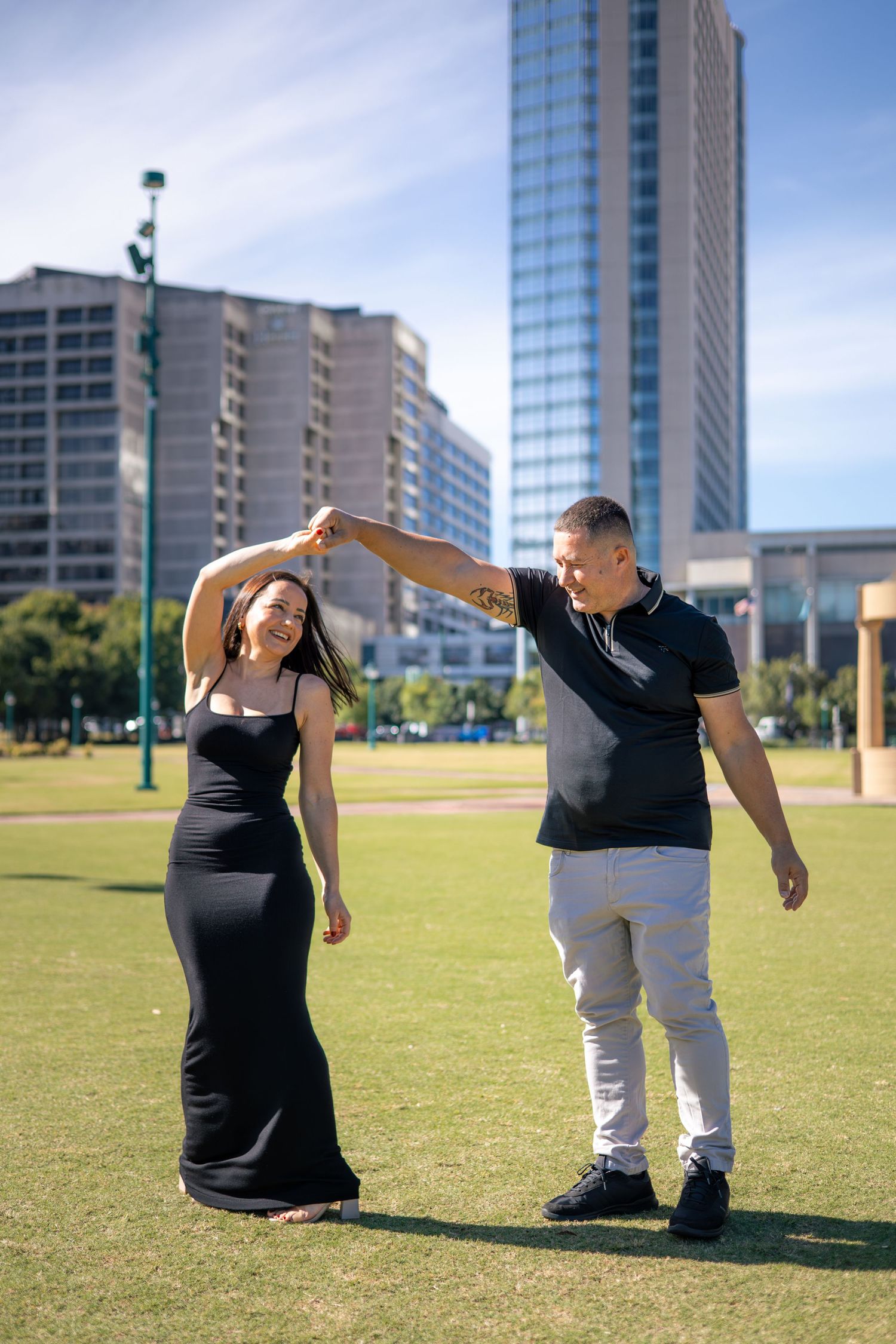 Playful couple poses in an urban setting with skyscrapers in the background.