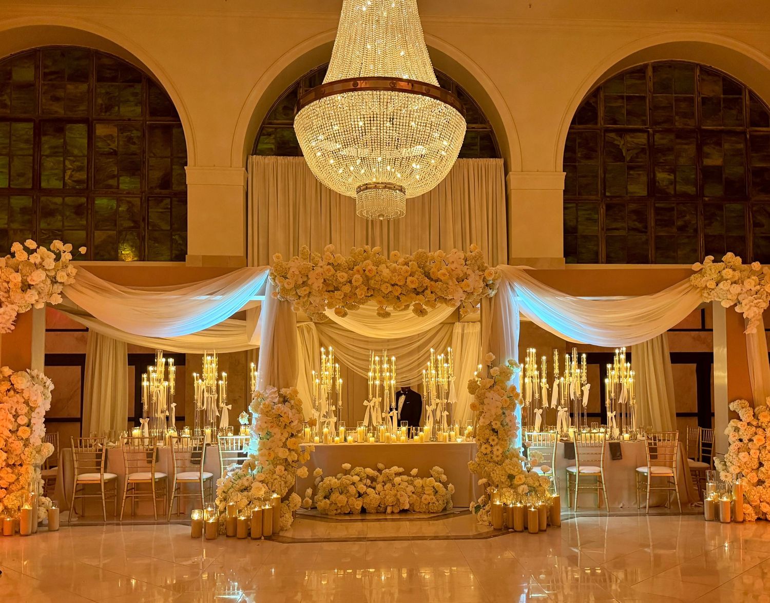 Luxurious wedding reception venue with crystal chandeliers and warm ambient lighting.