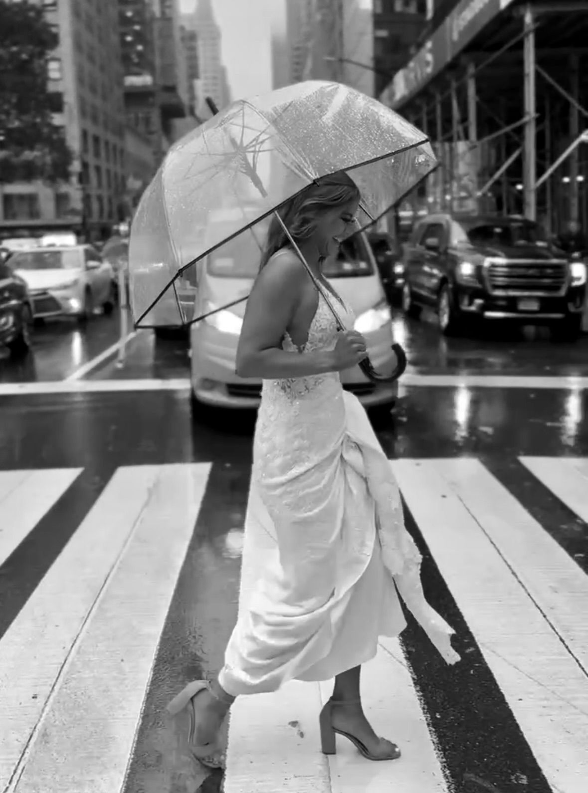 Artistic black and white photo series of a person crossing a rainy city street with an umbrella.