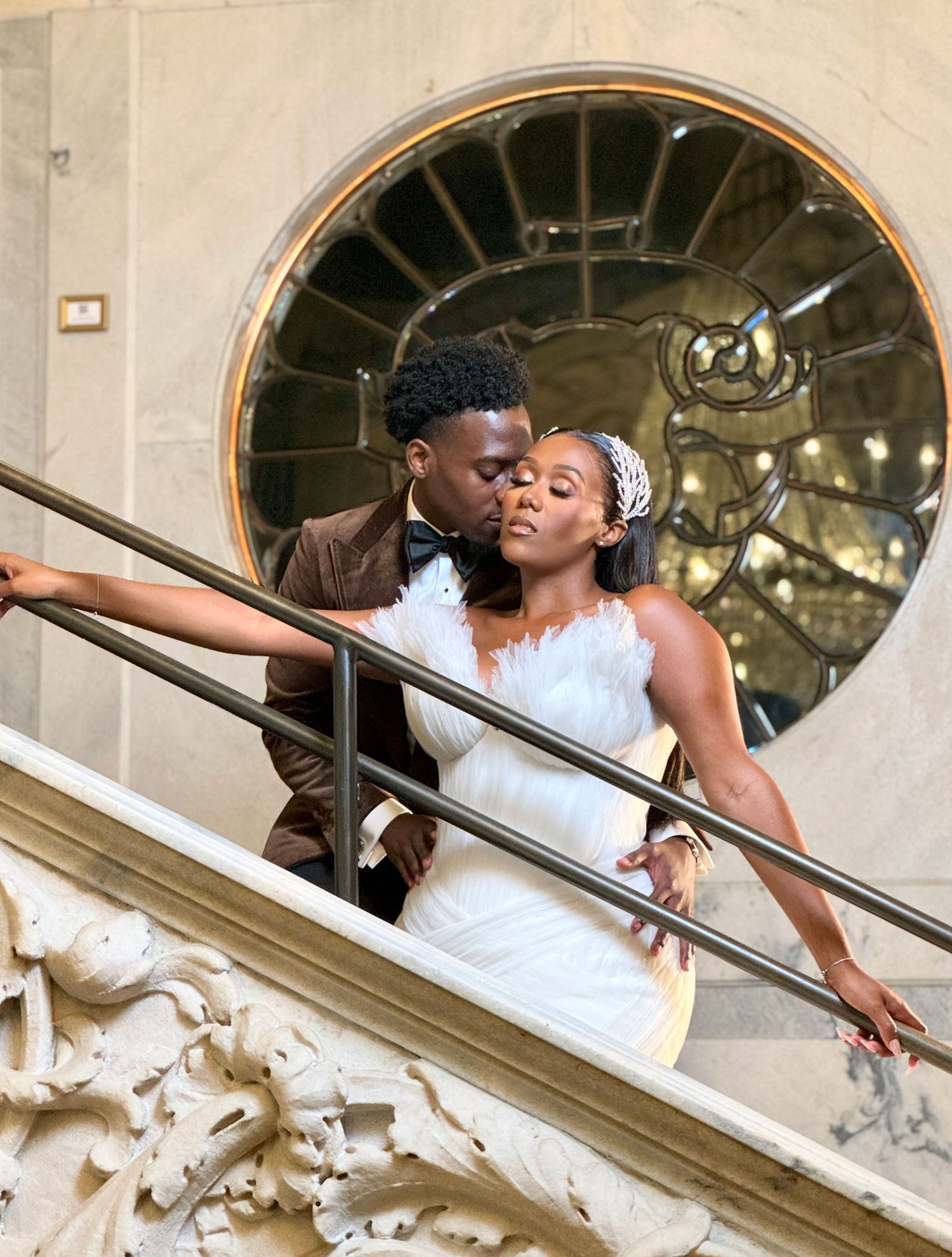 A romantic wedding photoshoot on an ornate staircase with elegant architectural details.