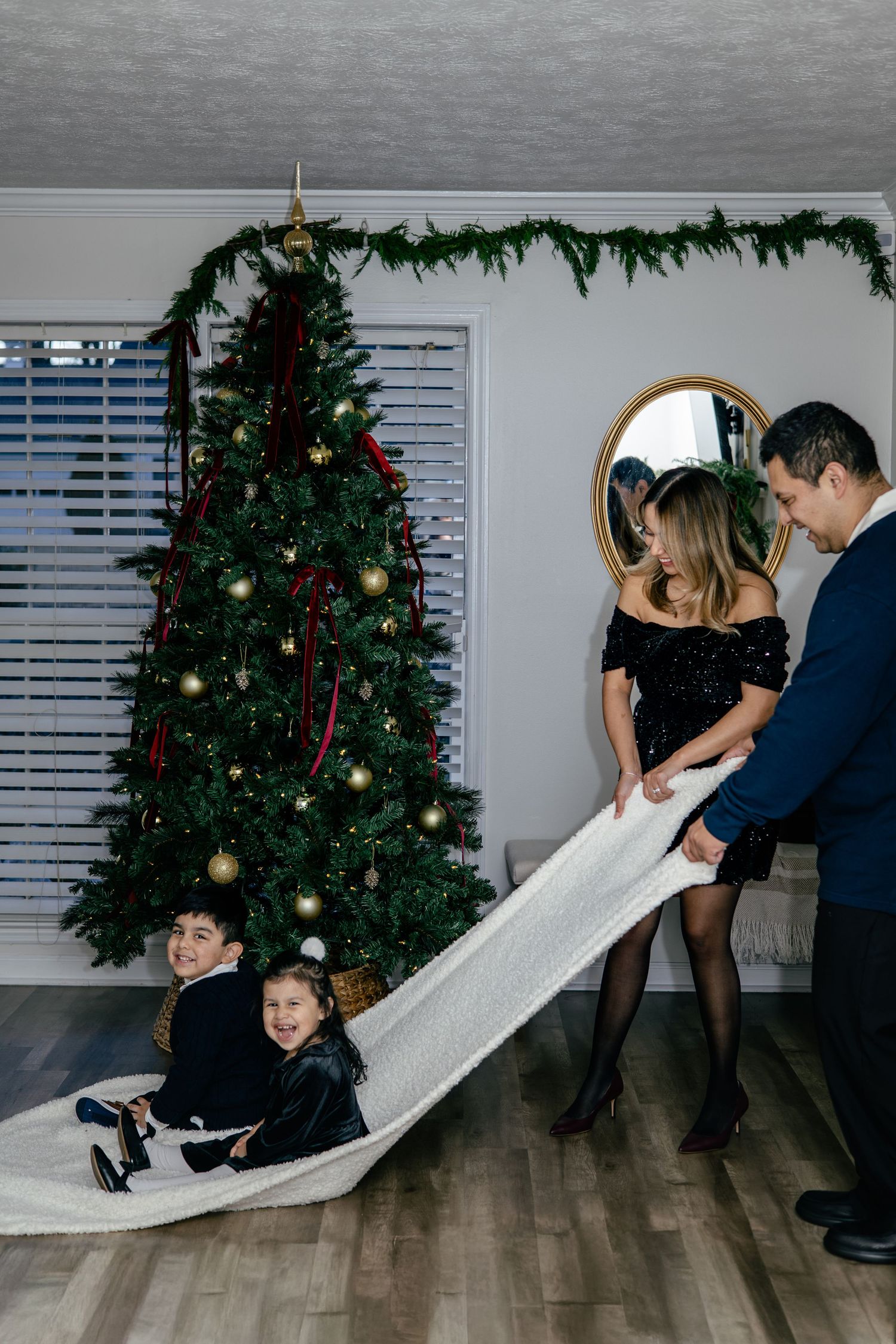 Joyful holiday celebration with family dancing by decorated Christmas tree.