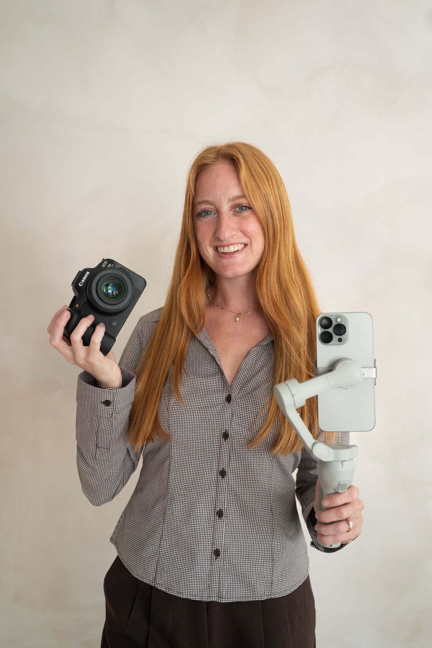 A photographer displays various camera equipment and gear against a light background.