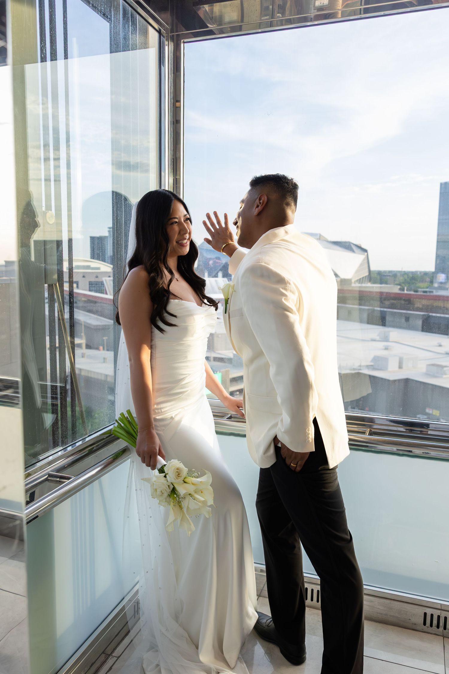 Groom seeing bride for first time in white gown during first look at venue.