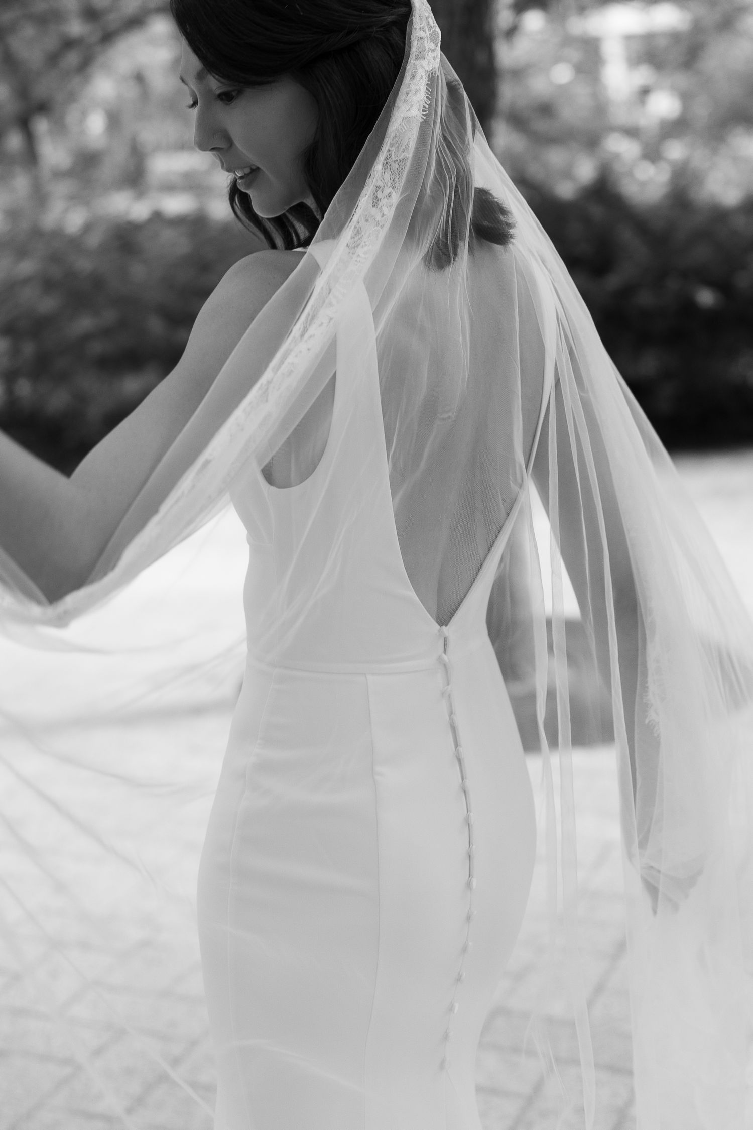 Ethereal white wedding veil billowing in the breeze against a soft blurred background.