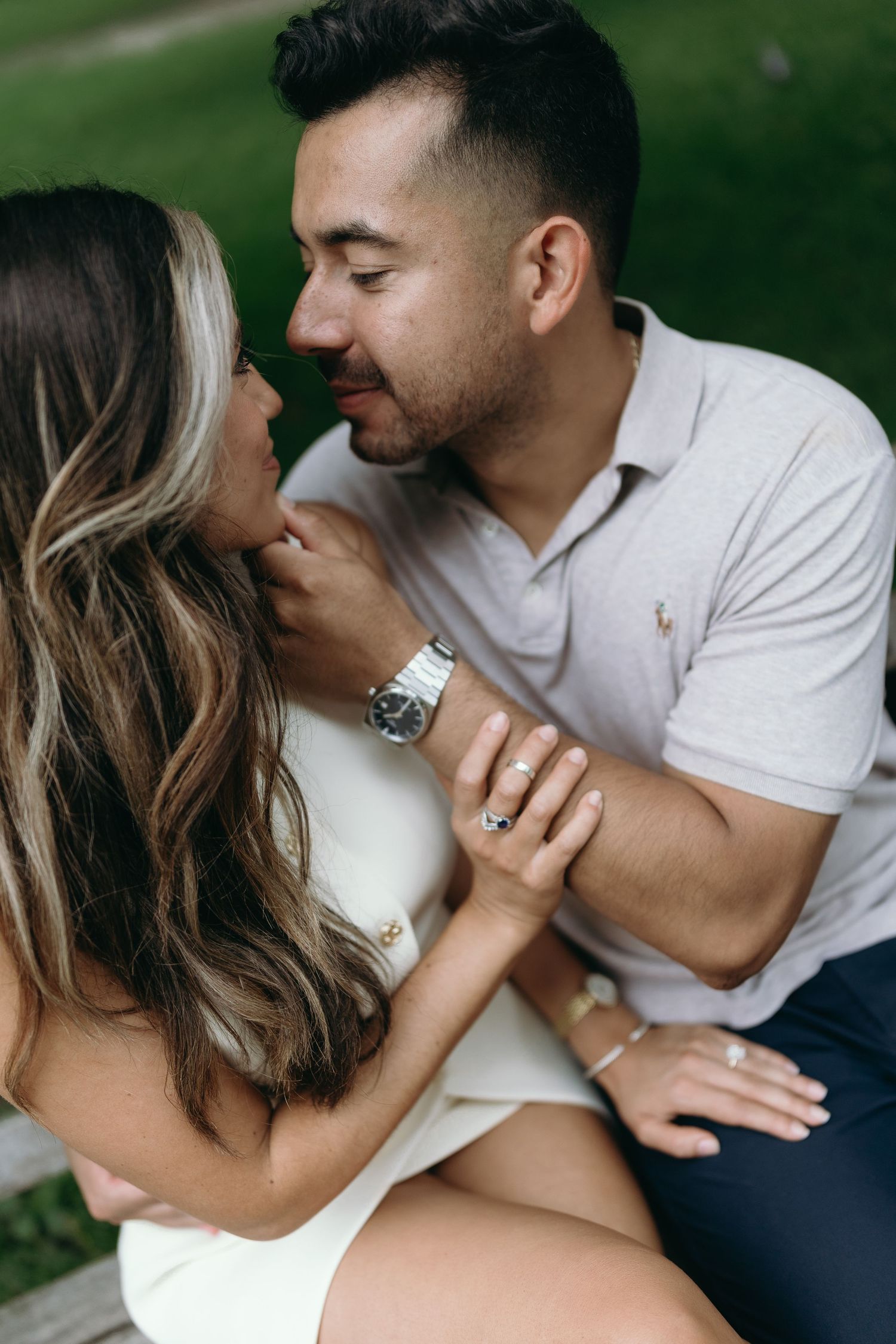 A romantic couple sharing tender moments together in a natural outdoor setting during an engagement photoshoot.