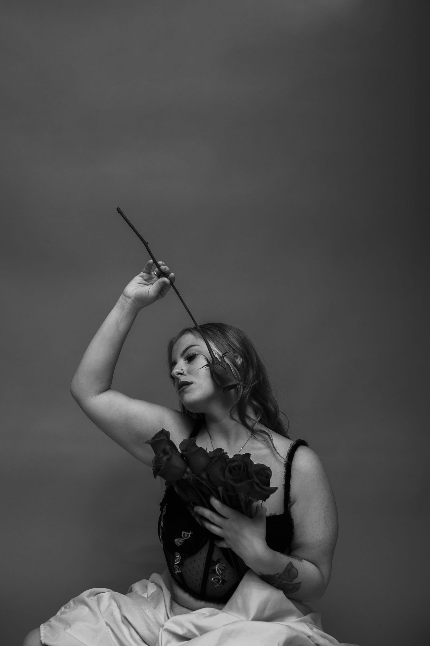 Artistic black and white portrait series showing sensual burlesque dancer poses with dramatic lighting and shadows.