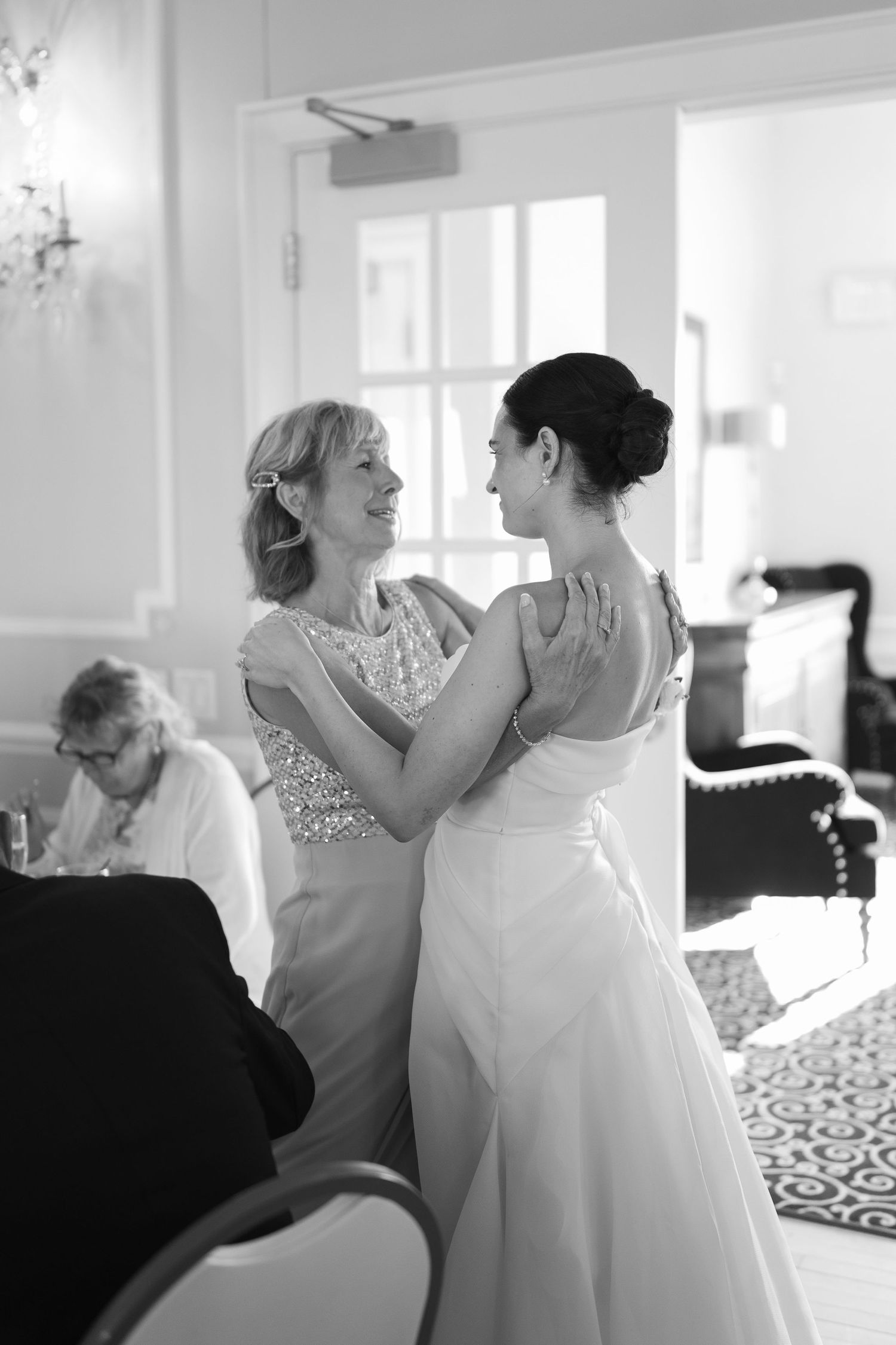 Intimate black and white moment shared between two in formal attire.