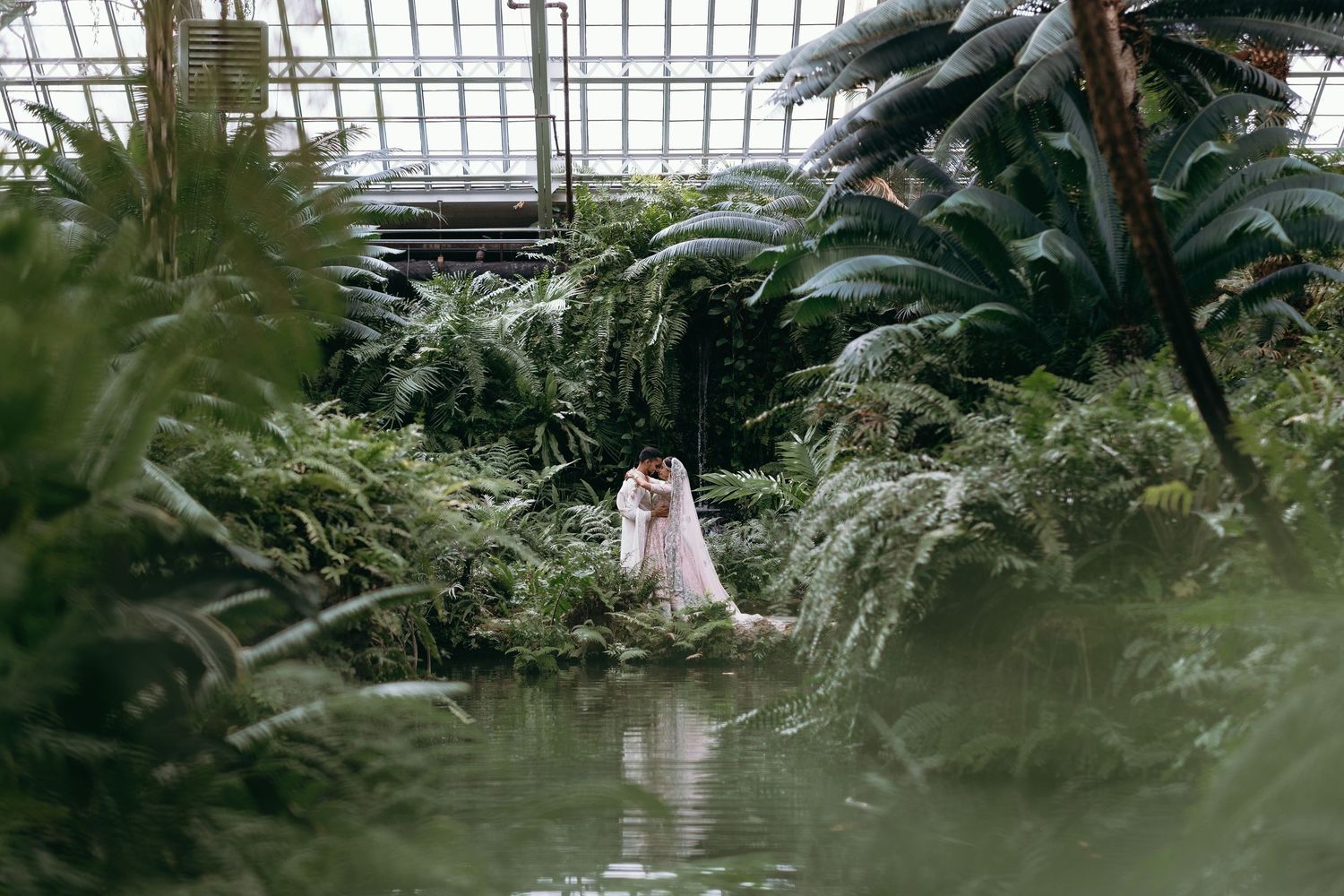 Lush greenhouse conservatory with tropical plants and natural lighting.