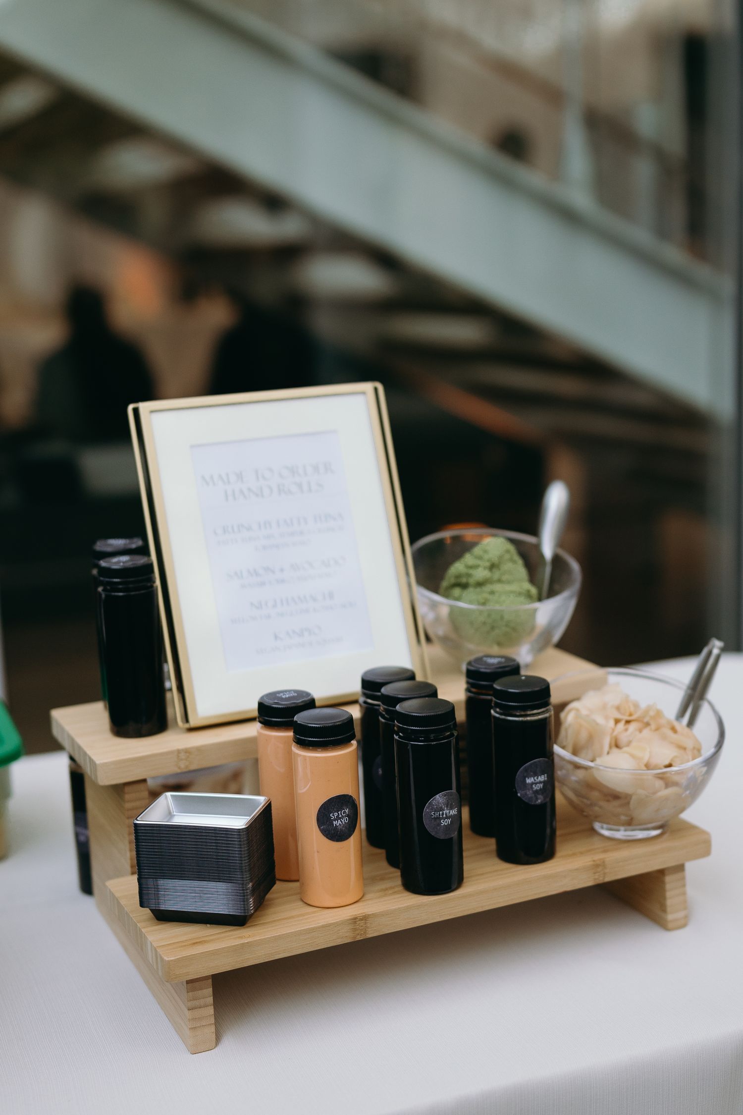 Wooden display stand with coffee service items and green ice cream at event.