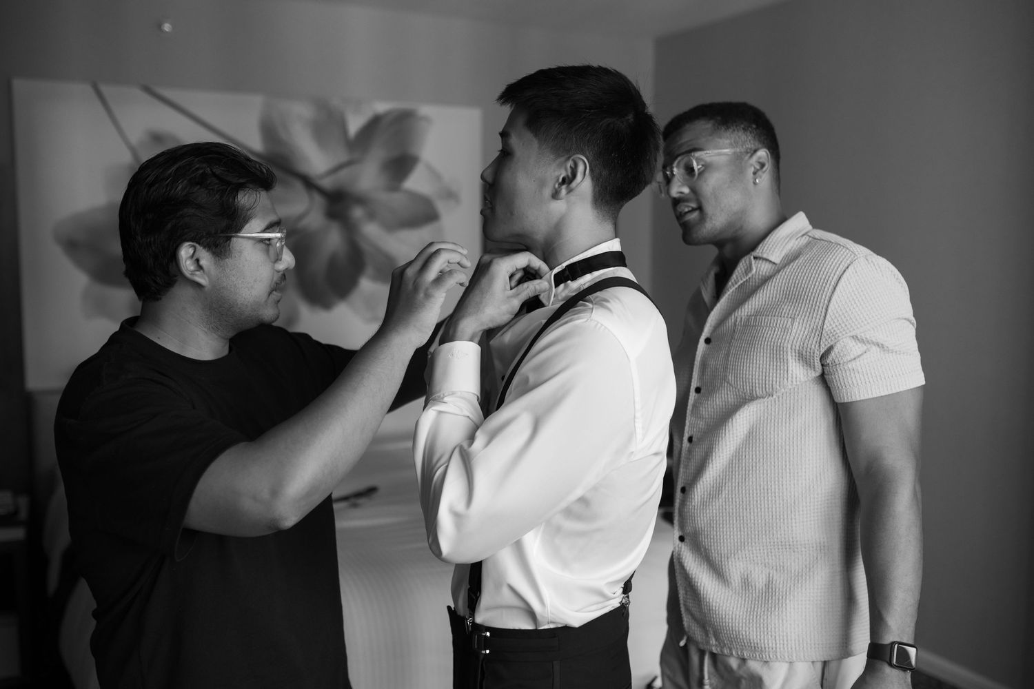 Black and white photo of wedding preparation with groomsmen getting ready.