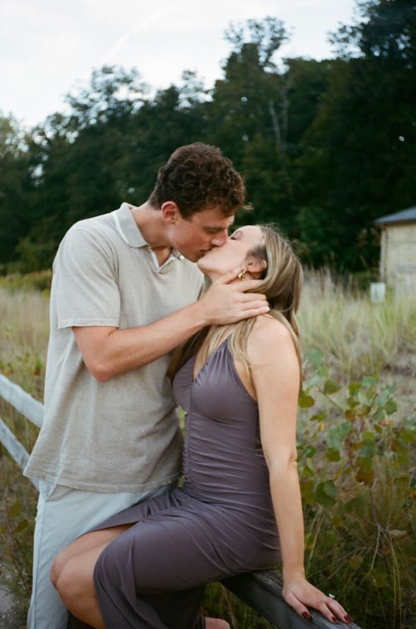 Romantic couple sharing intimate moment on rustic wooden boardwalk surrounded by tall grass. Chicago Film wedding photographer
