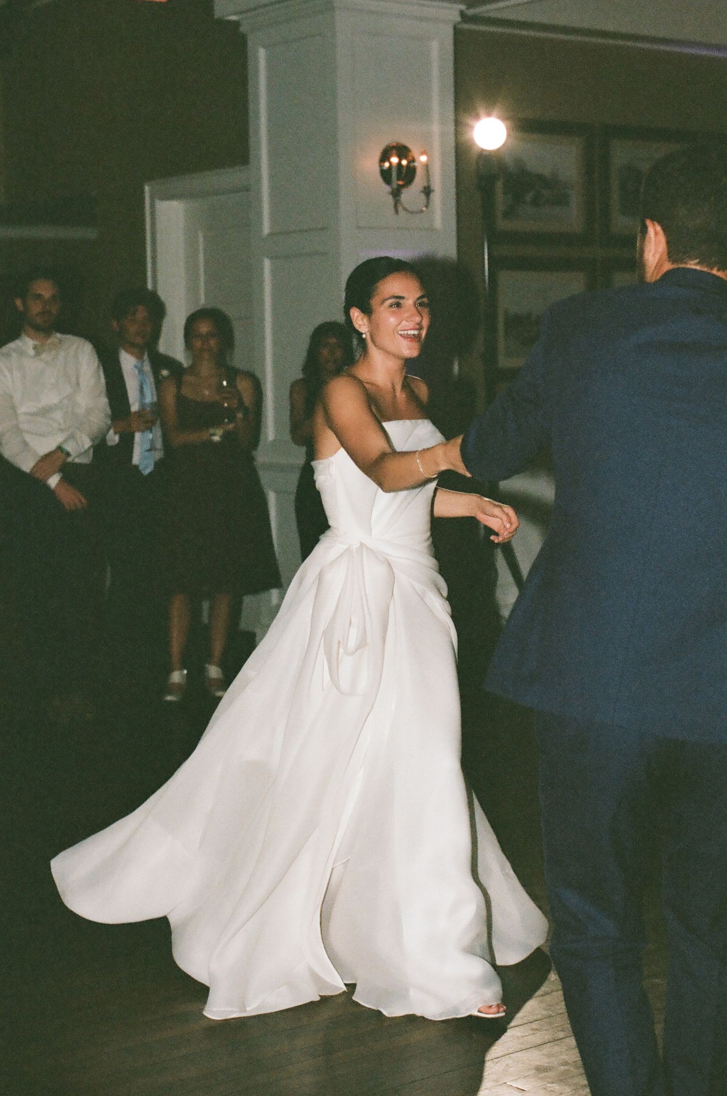 A joyful dance moment at a wedding reception with a twirling white gown.