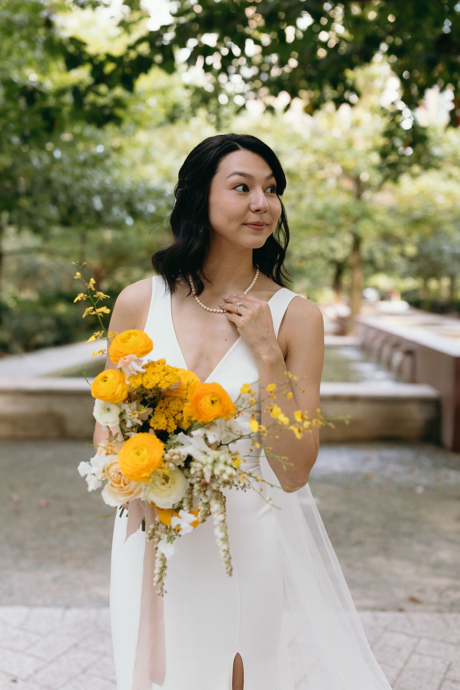 Candid bridal moments captured in a garden setting with yellow floral accents.