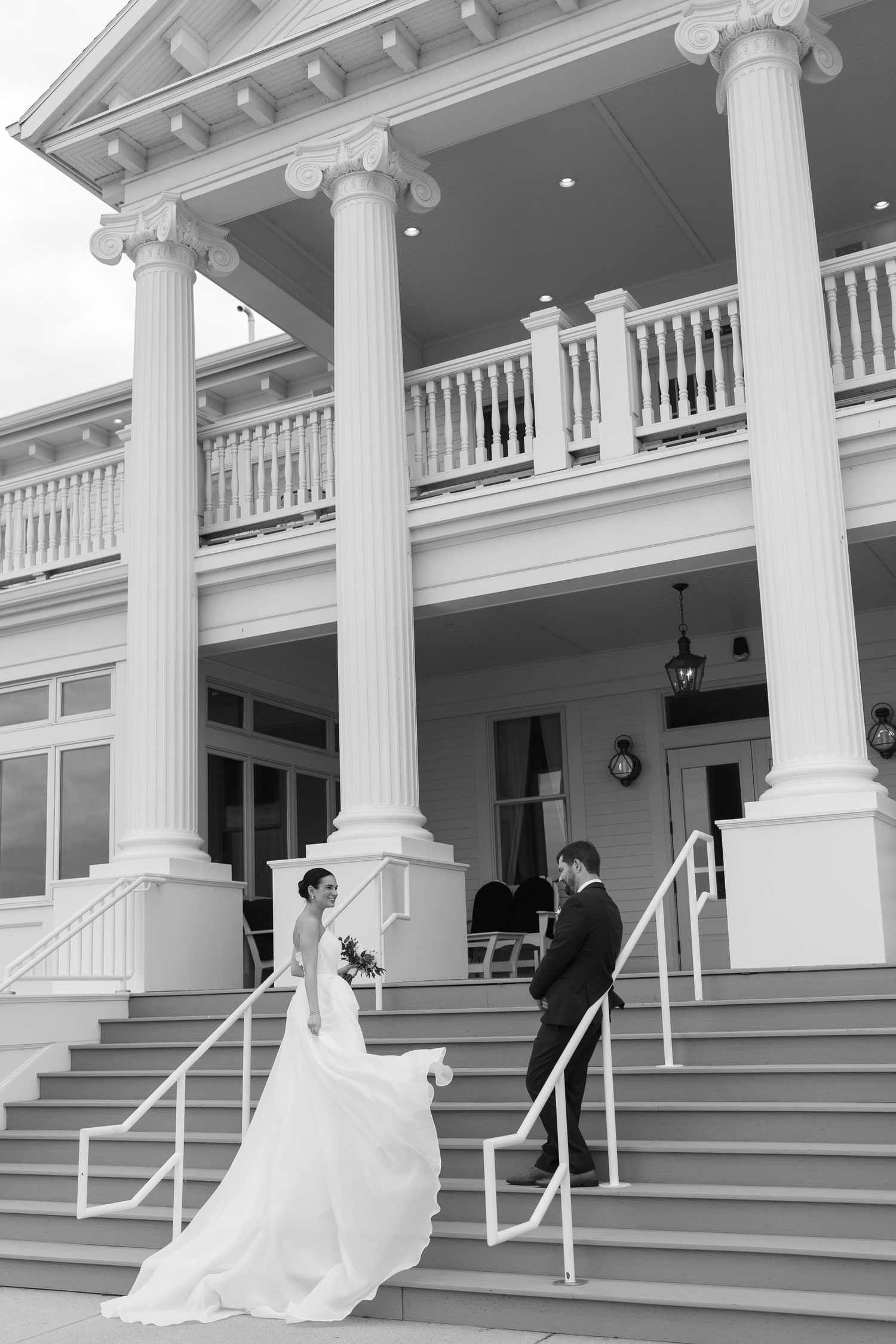 A sequence of black and white photos showing a wedding couple's first look moment on an elegant columned porch.
