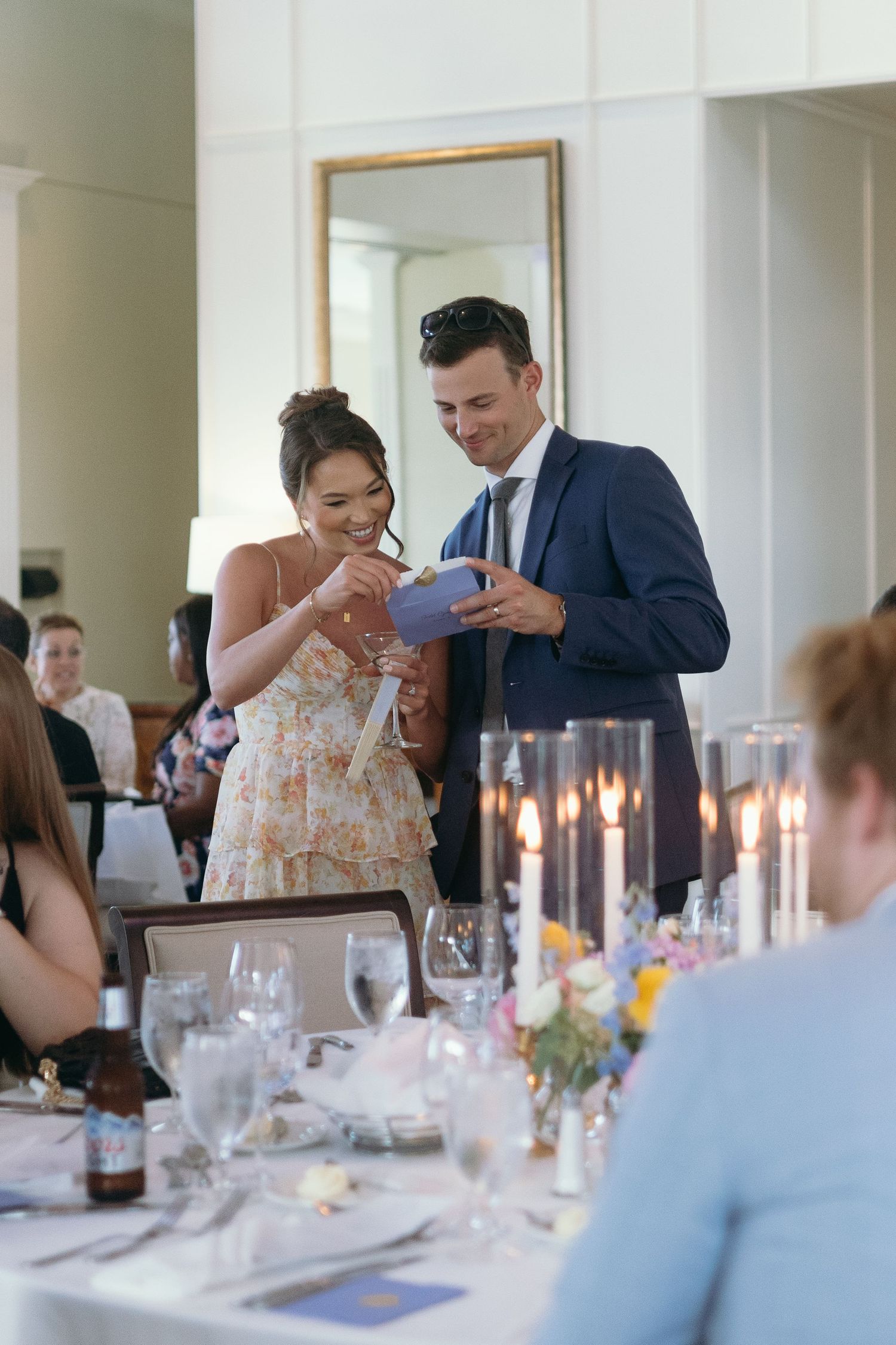 Wedding guests sharing a moment at an elegant reception table with candlelight.