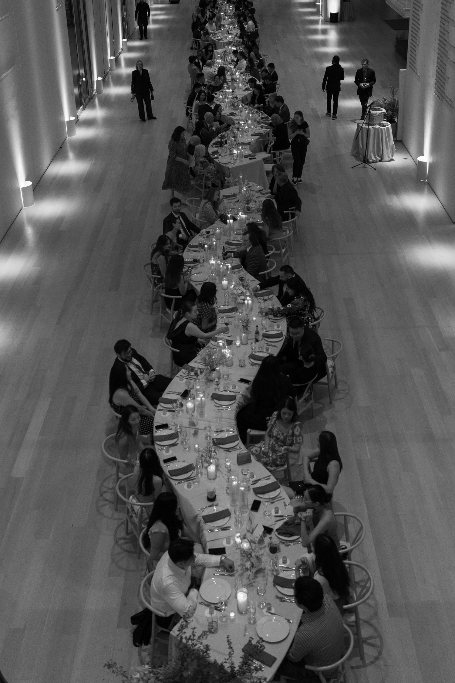 Aerial view of a formal dinner setup with long tables and seated guests.