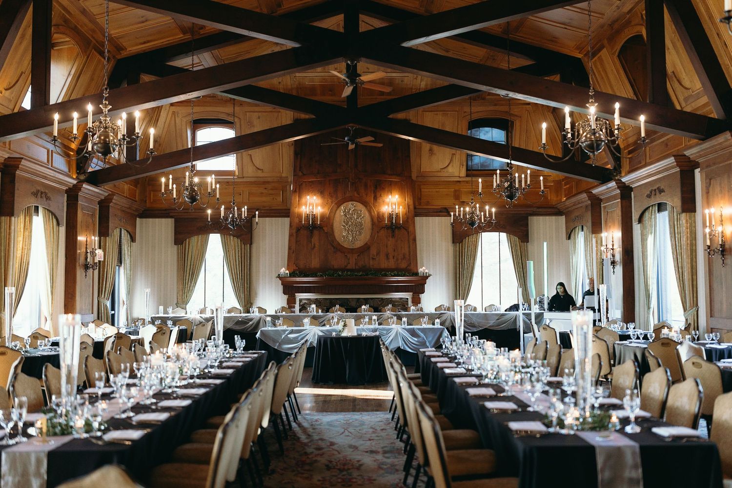 Rustic wooden reception hall with exposed beams and elegant table settings.