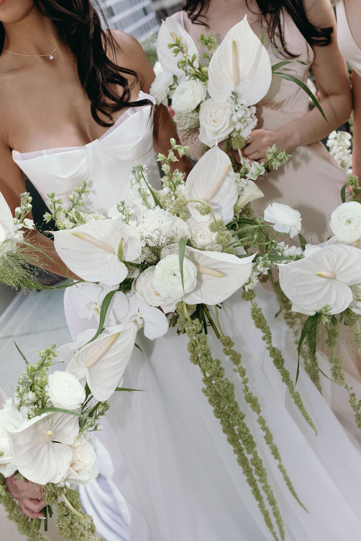 Wedding bouquets featuring elegant white flowers and cascading green amaranthus create a romantic bridal arrangement.