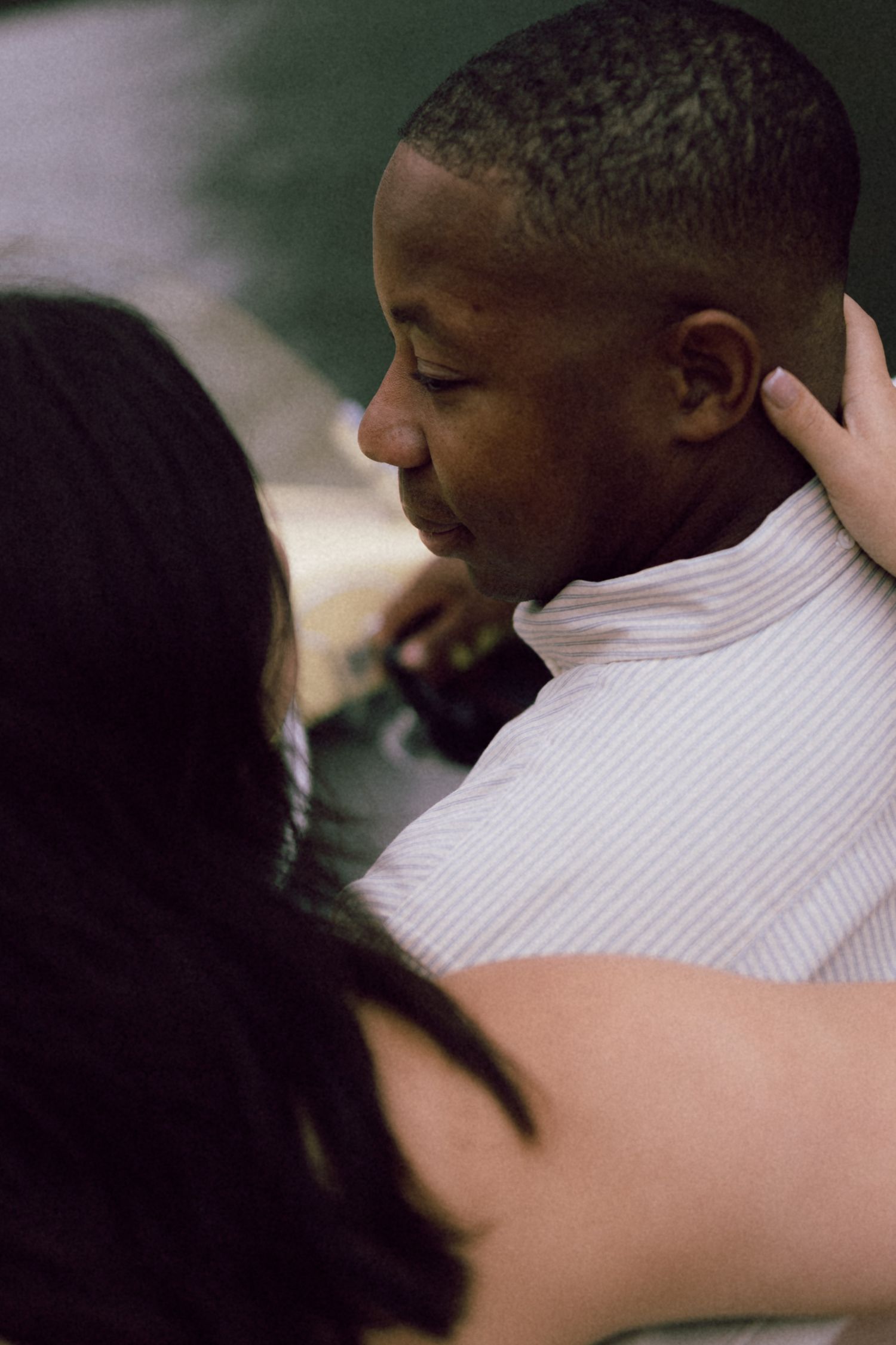 A couple shares an intimate embrace, with a woman tenderly holding a man's face in a close, emotional moment.