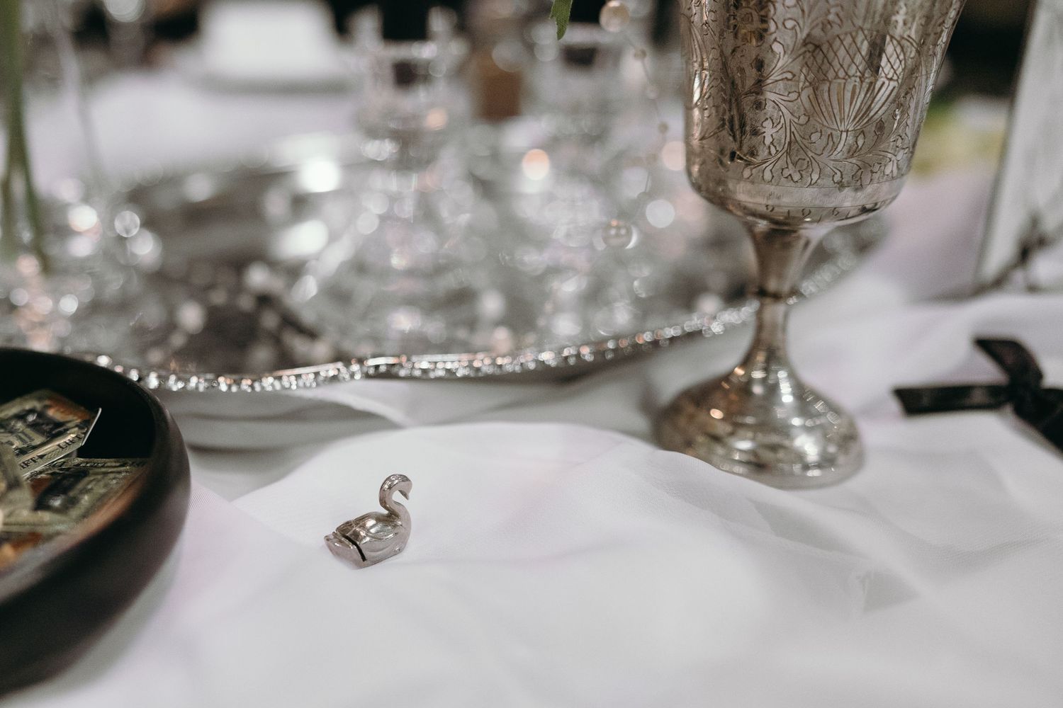 Wedding rings displayed on white linen next to elegant silver champagne flutes.