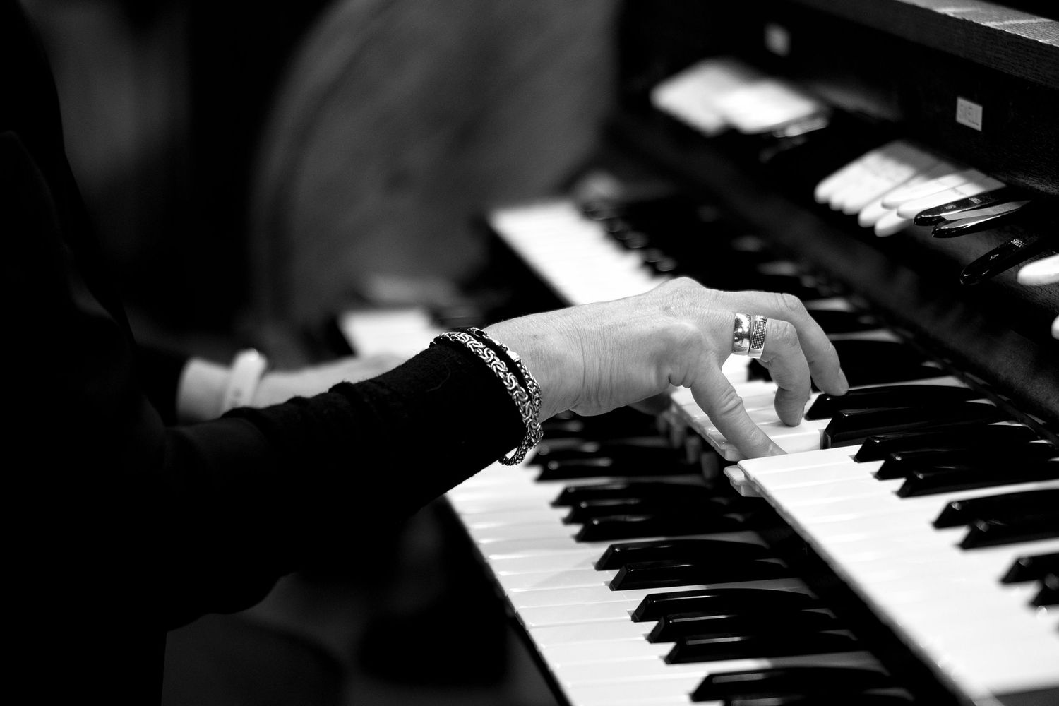 Close-up view of piano keys in dramatic black and white lighting.
