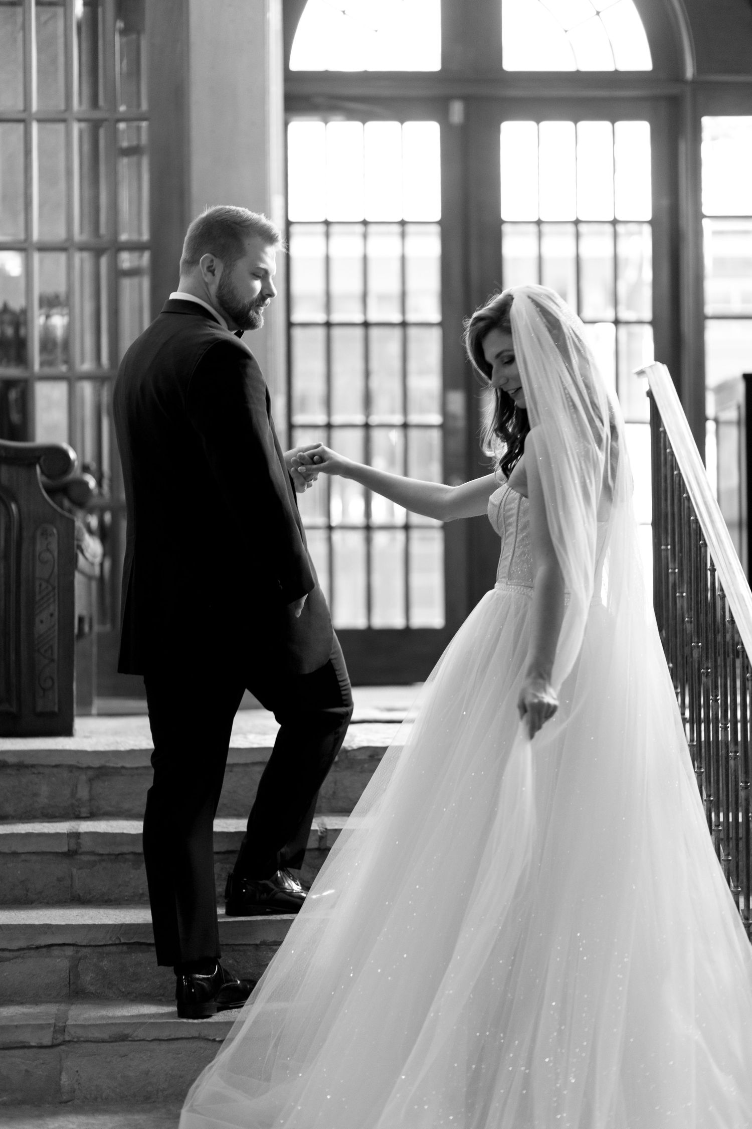 A tender moment captured on elegant stairs during a wedding ceremony.