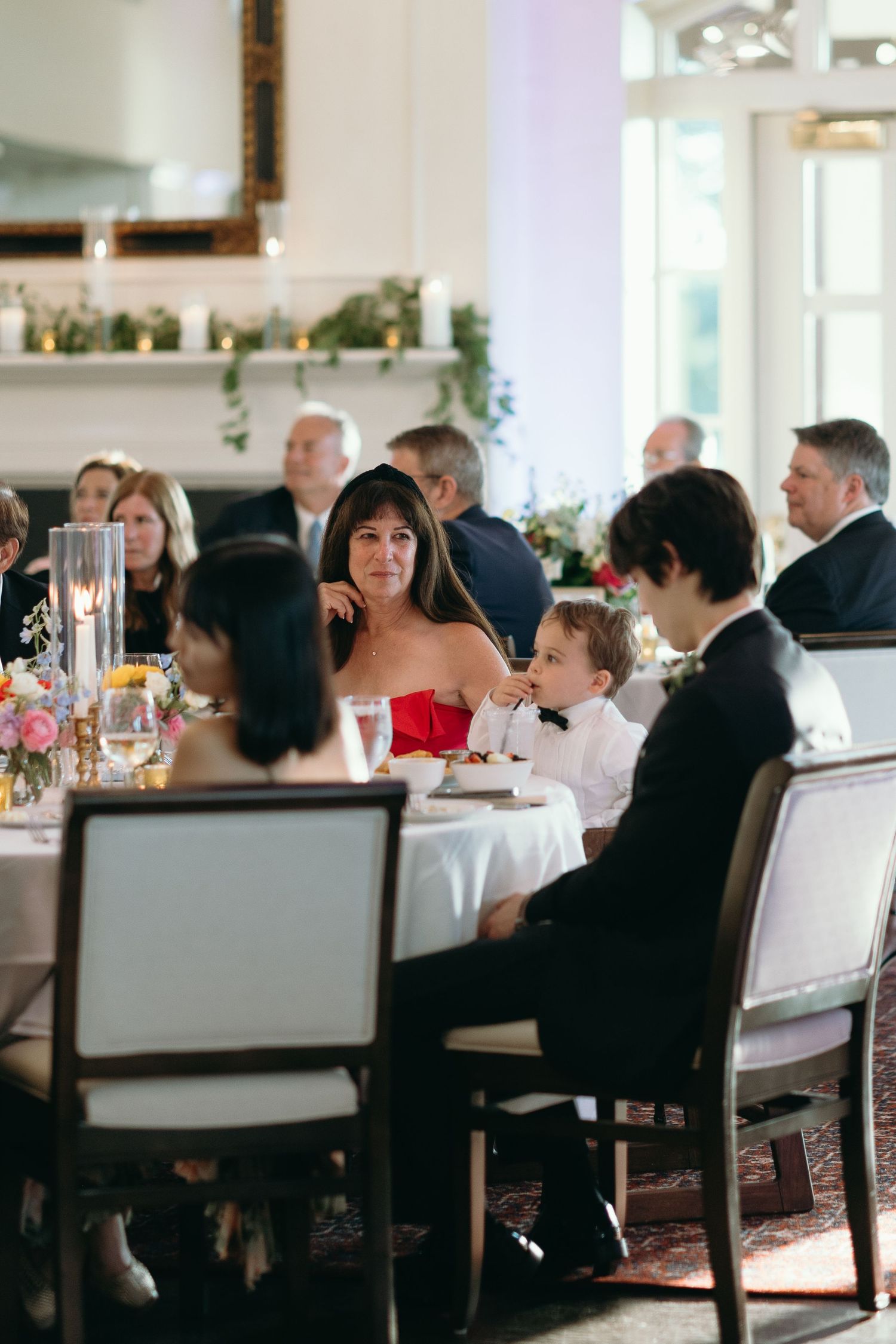 Guests seated at elegant tables during formal wedding reception dinner.