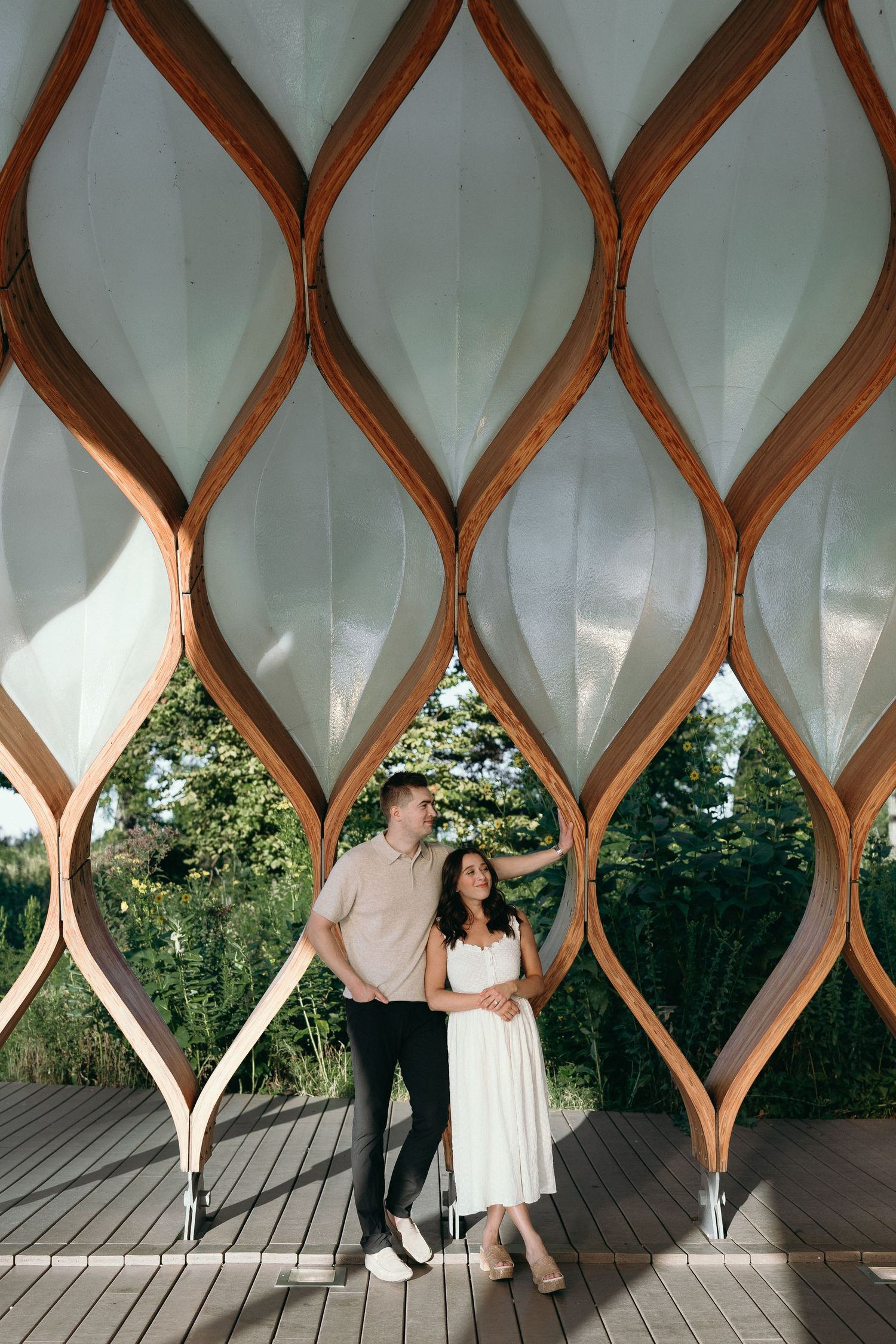 A series of romantic engagement photos showing couples posing behind wooden lattice walls in an outdoor setting.