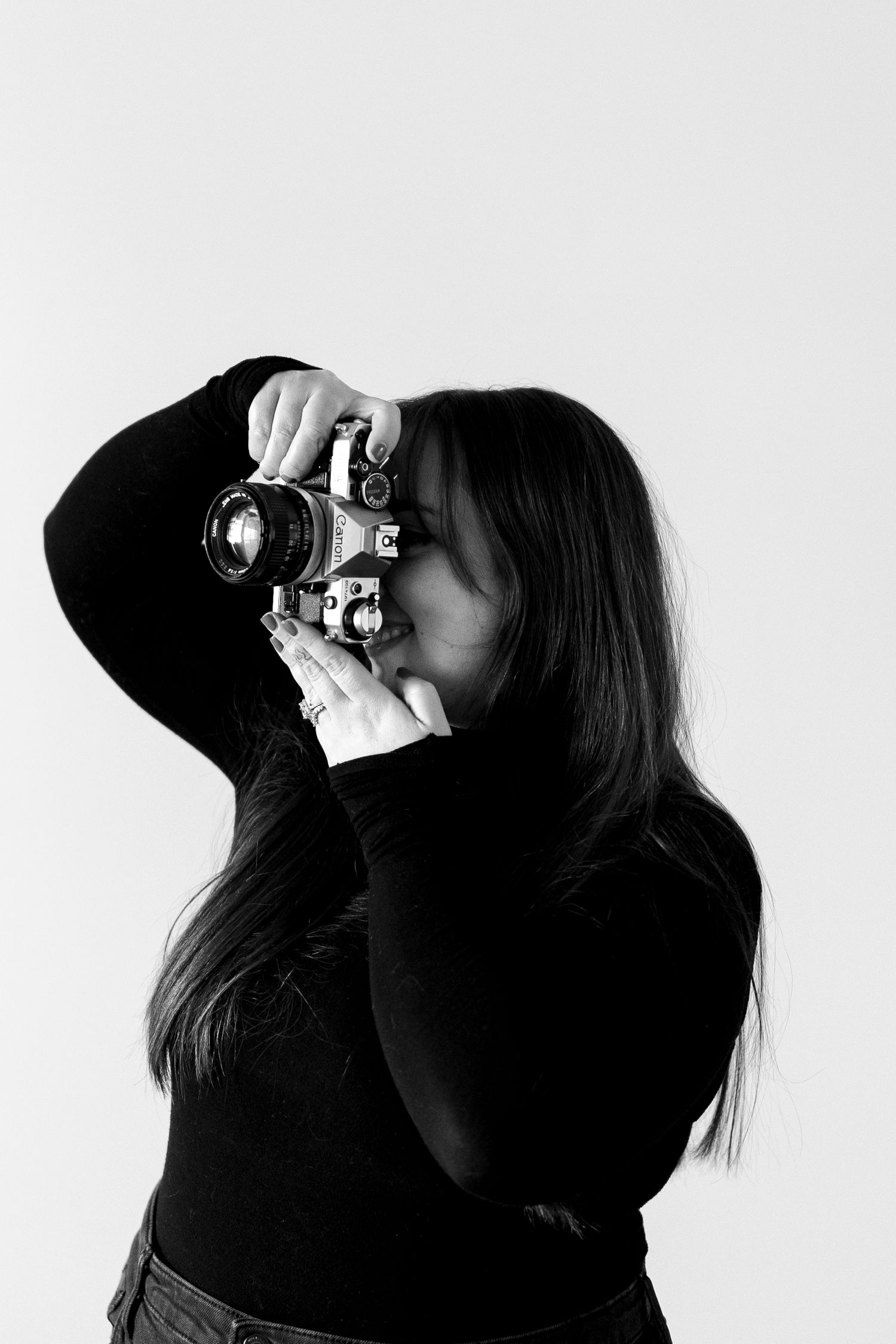 Black and white portrait of a photographer taking a picture with a vintage camera.