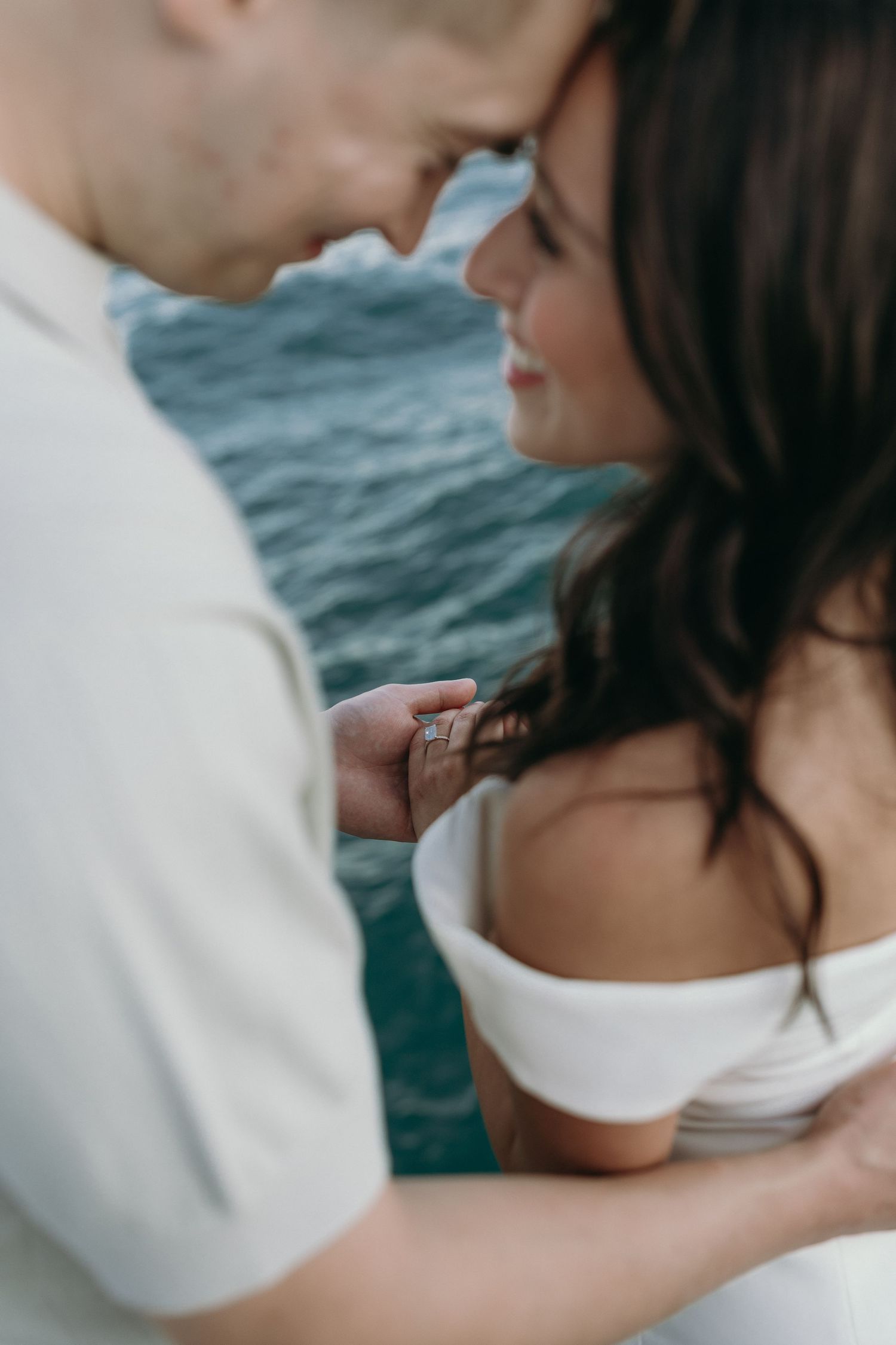Romantic series of cropped shots showing tender intimate moments between a couple against a blue ocean background.