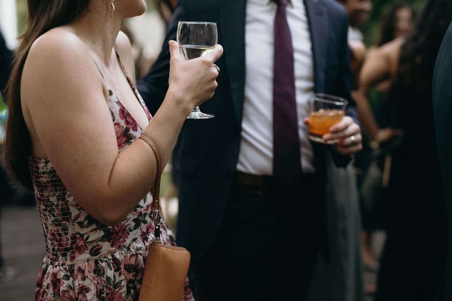 Guests holding wine glasses at a formal evening reception.