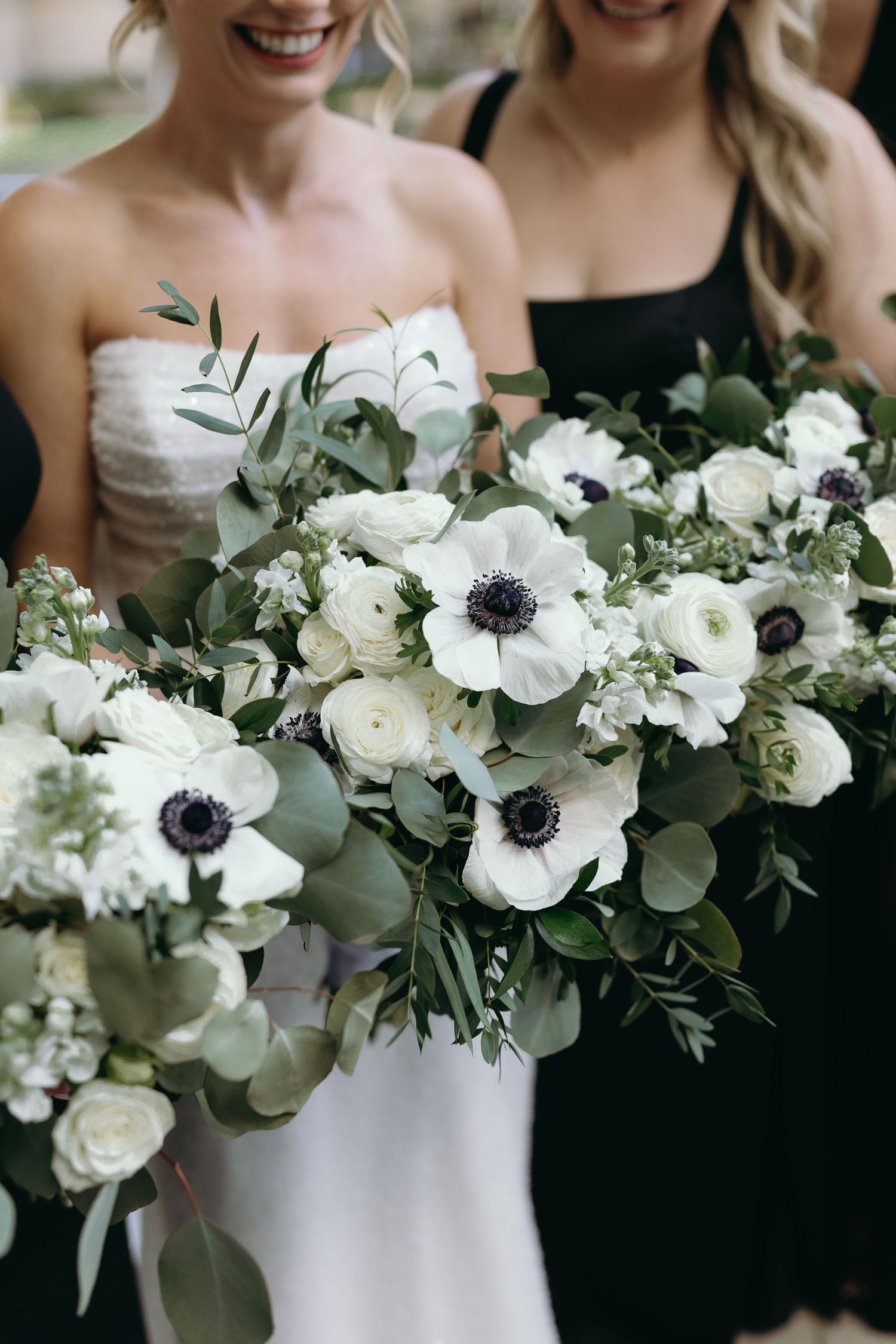 A stunning bridal bouquet featuring white anemones, roses and eucalyptus greenery.