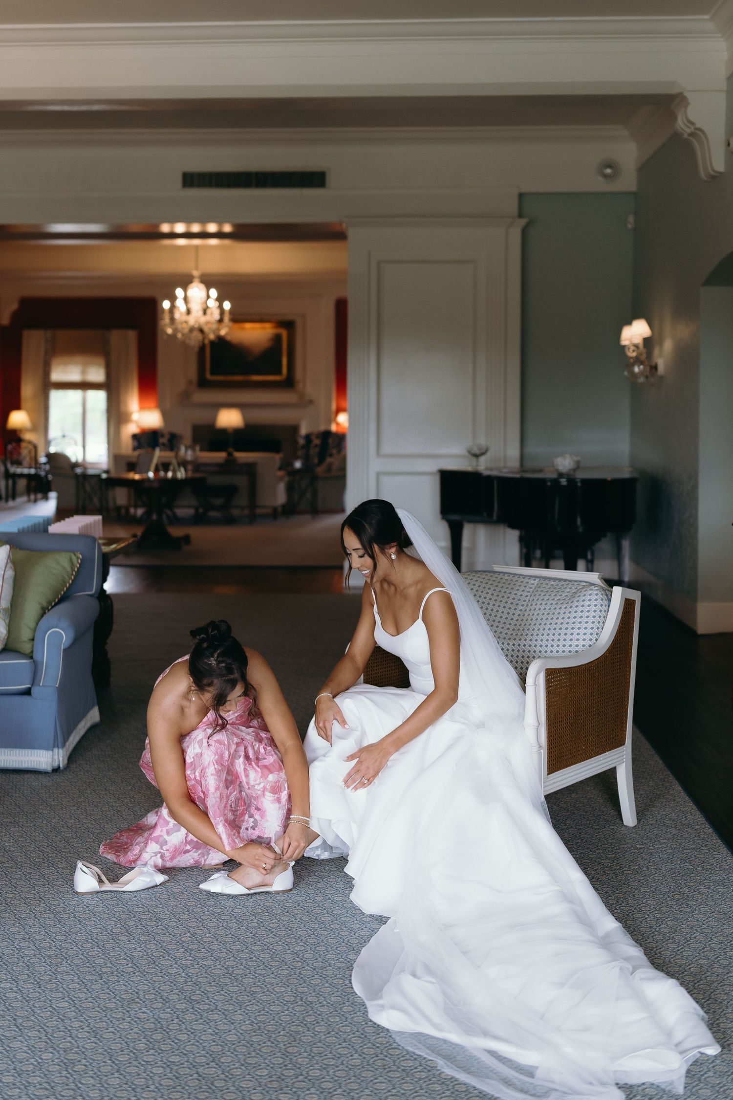 Wedding preparations in an elegant room with chandelier and modern furniture.