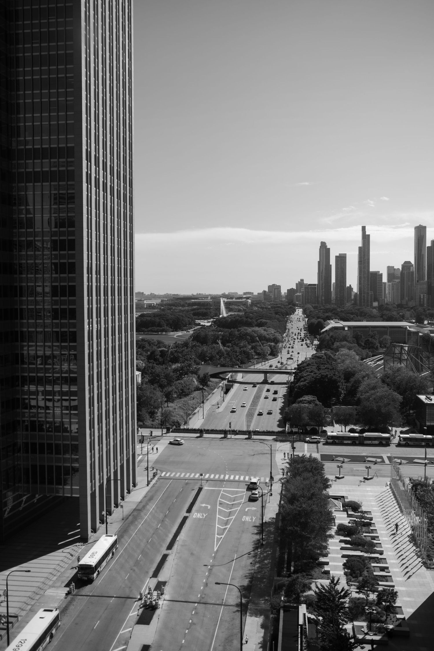 Black and white aerial cityscape of Chicago with highway leading to downtown skyline.