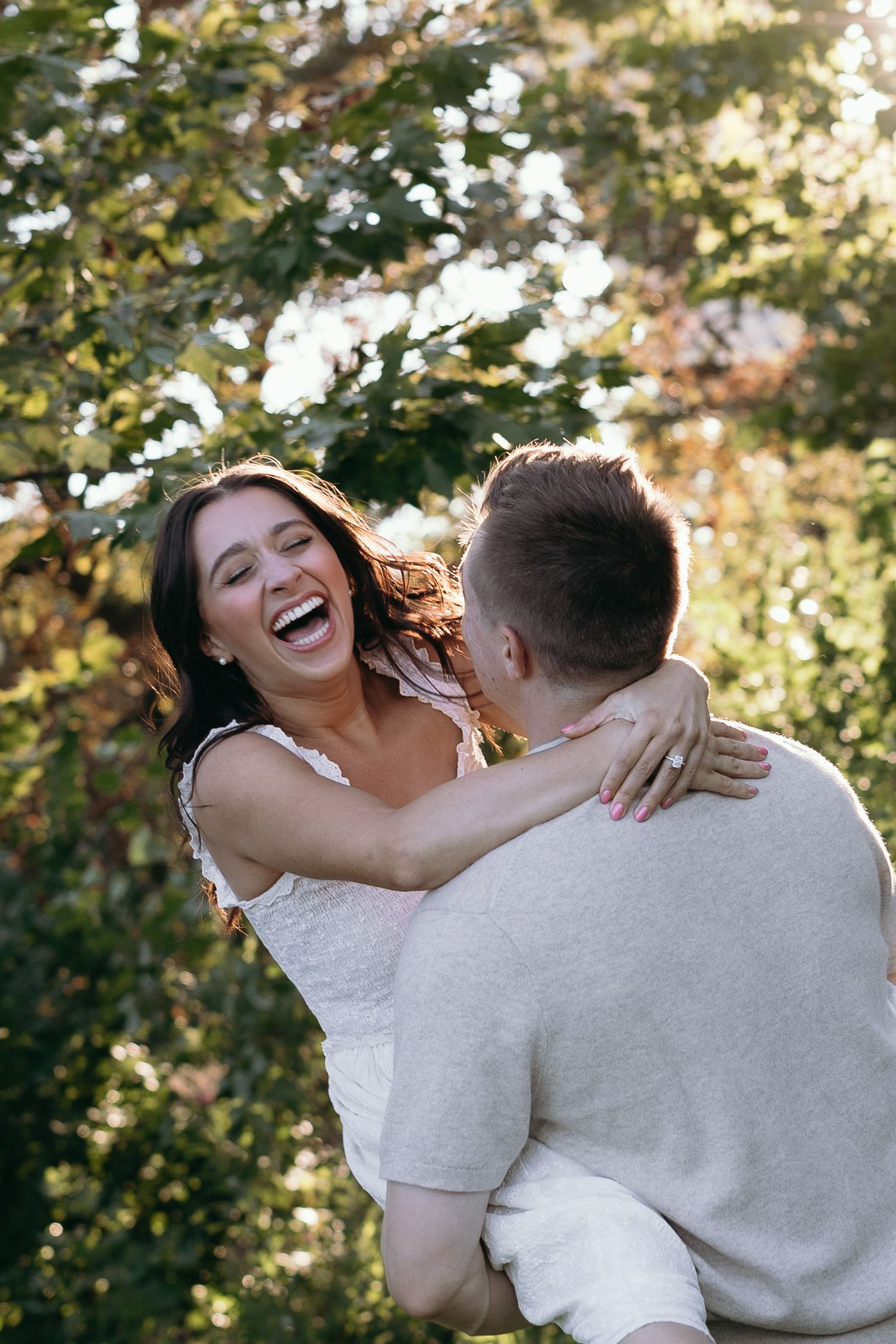 A candid series of joyful moments captured between a couple embracing outdoors with natural sunlit foliage in the background.