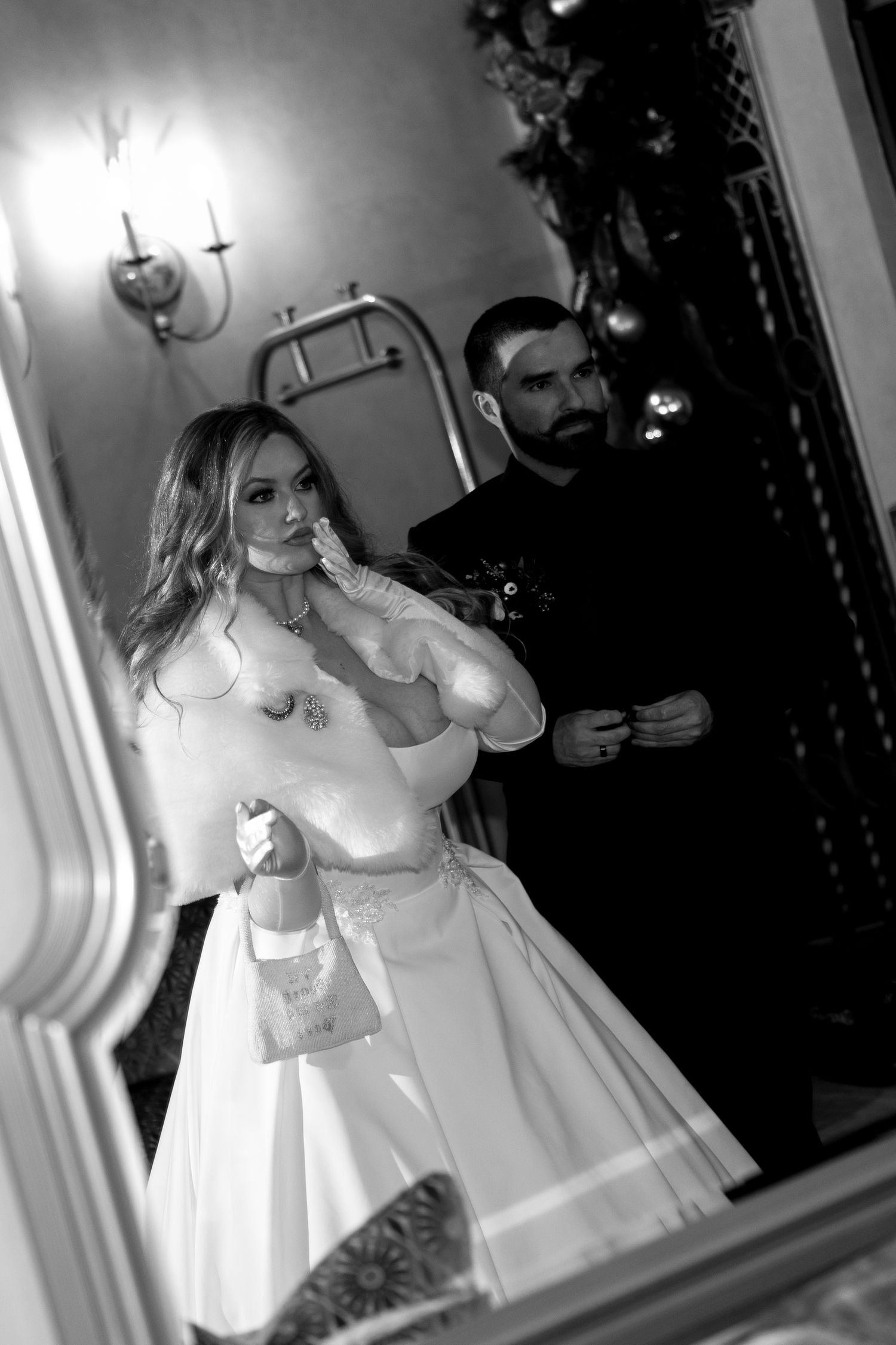 Bride in a white dress poses for artistic black and white mirror reflection shots.