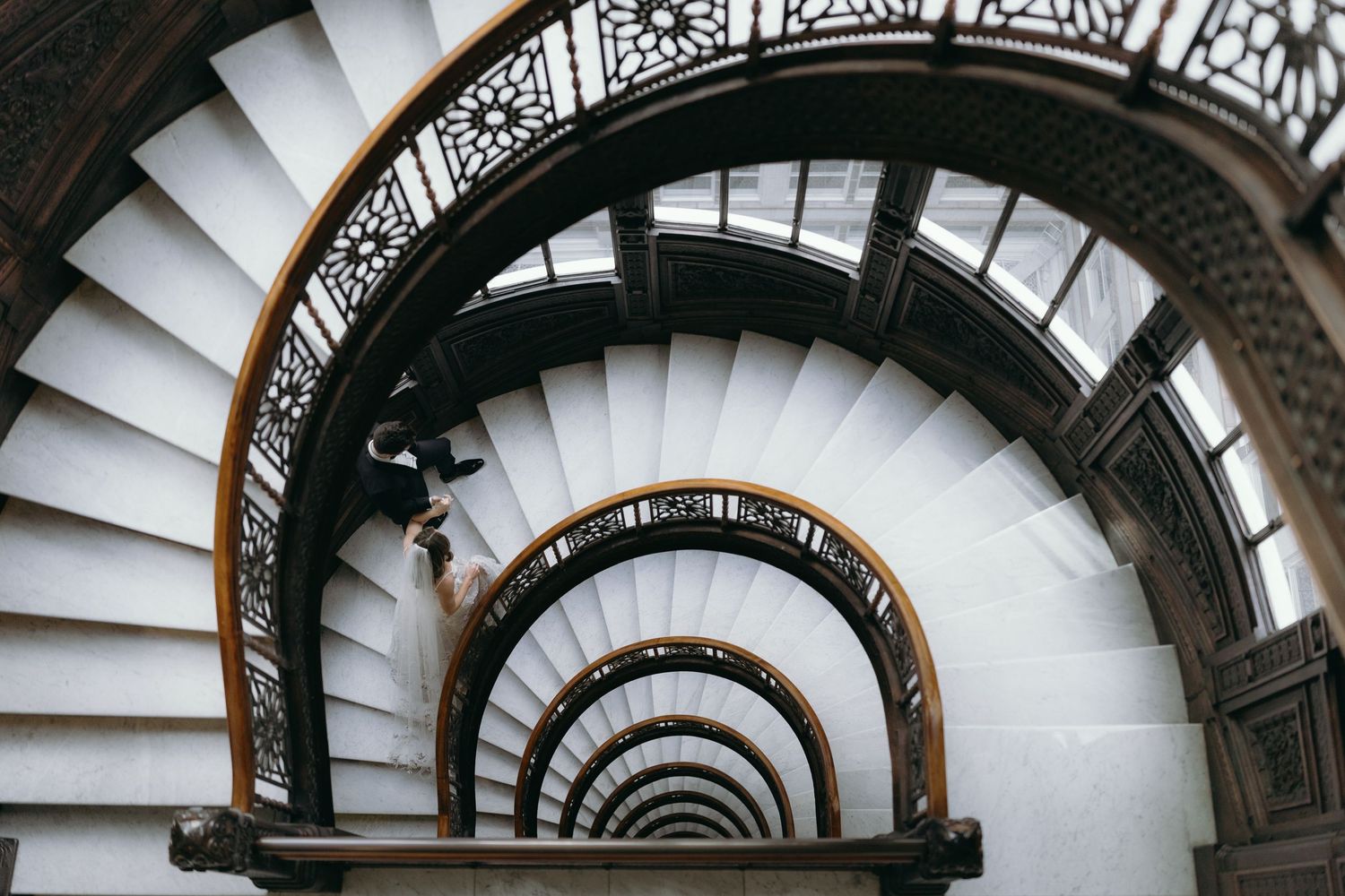 Elegant spiral staircase with ornate railings and natural lighting creates a dramatic architectural perspective.