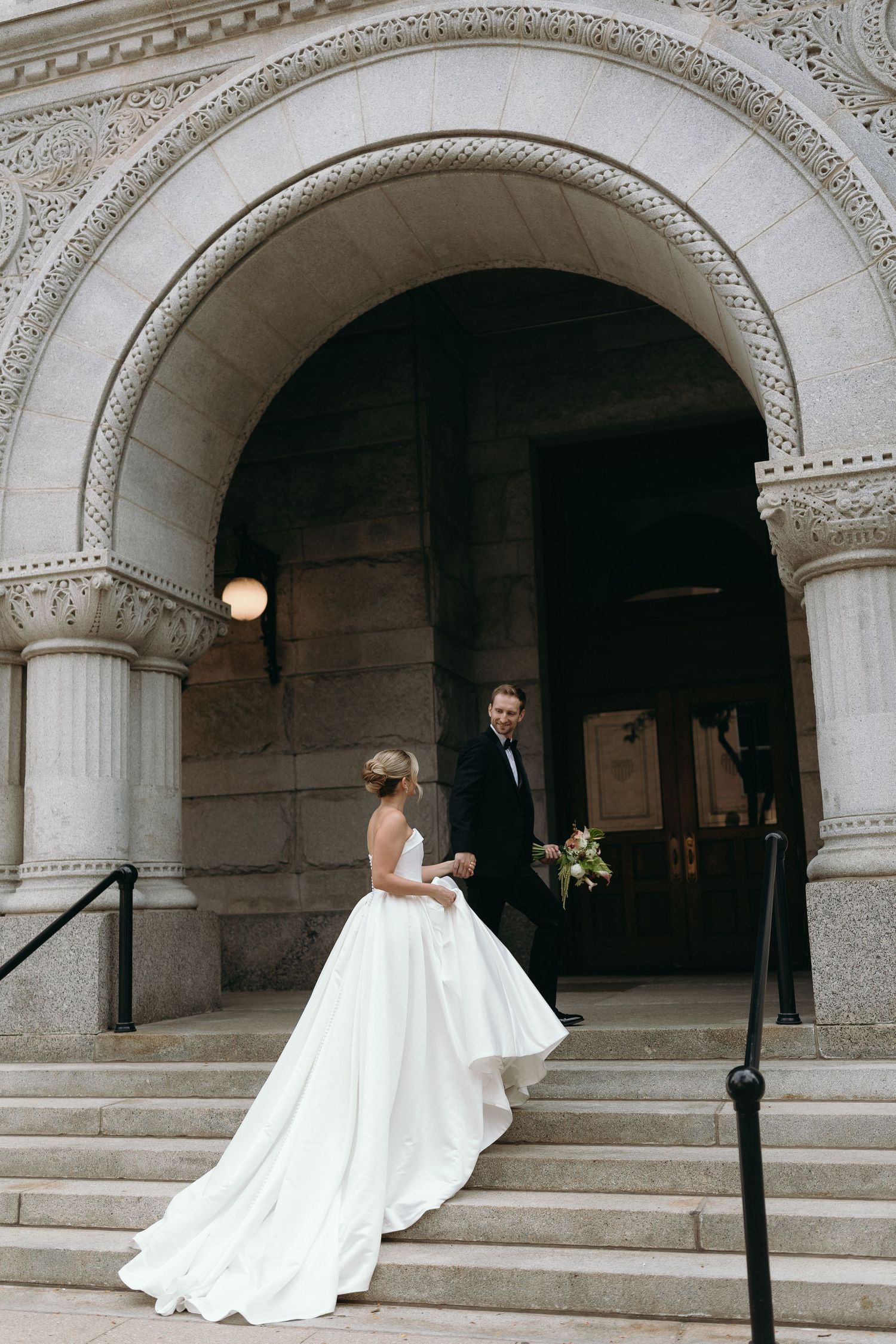 A wedding couple poses under ornate stone archways in a series of romantic progression shots.