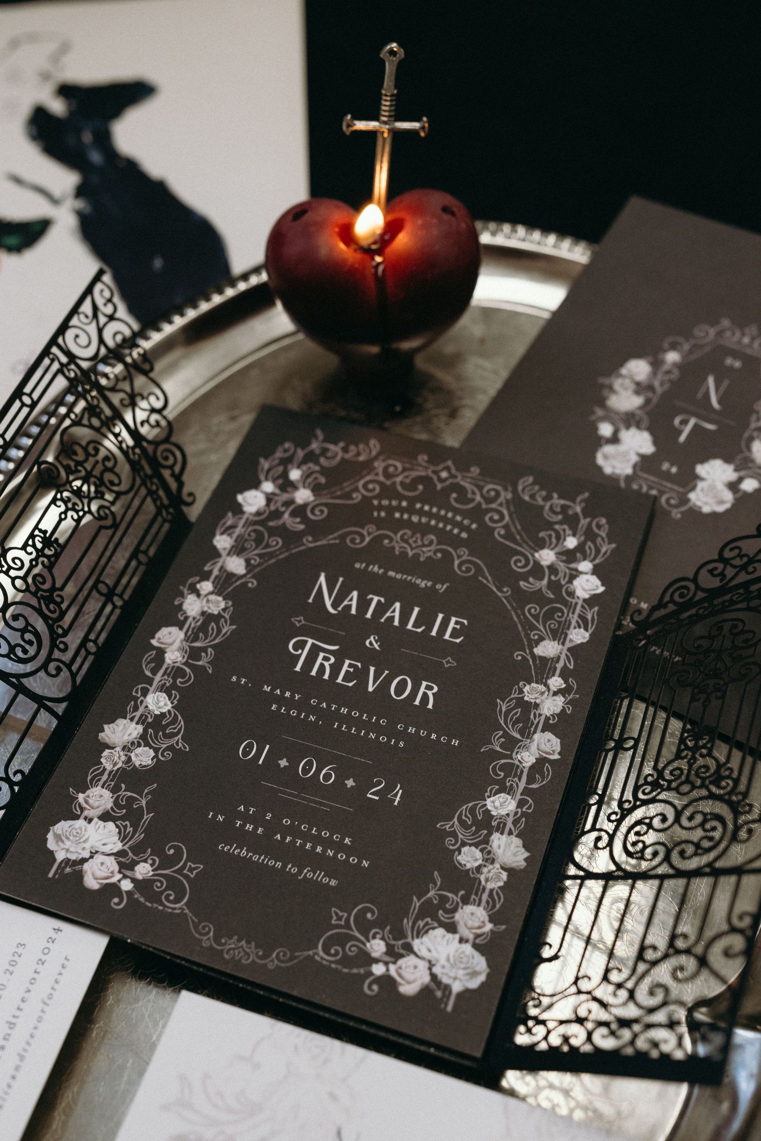 Dark gothic wedding invitation with a decorative cherry and sword detail.