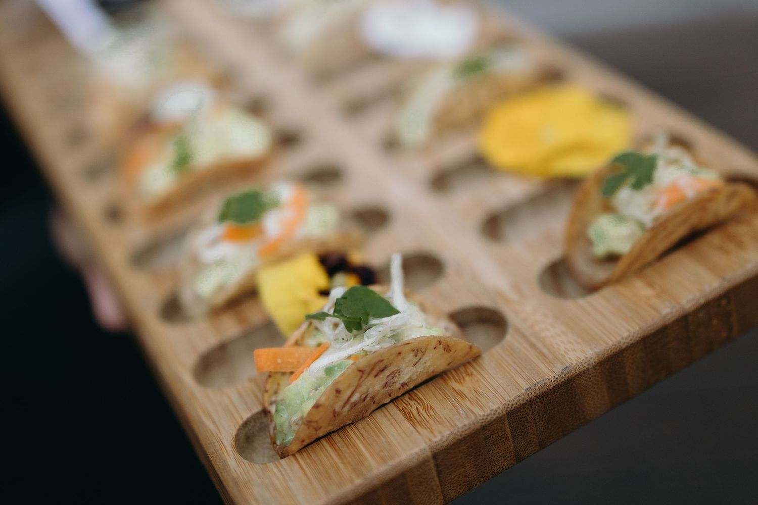 Appetizers served on wooden serving board with colorful garnishes.